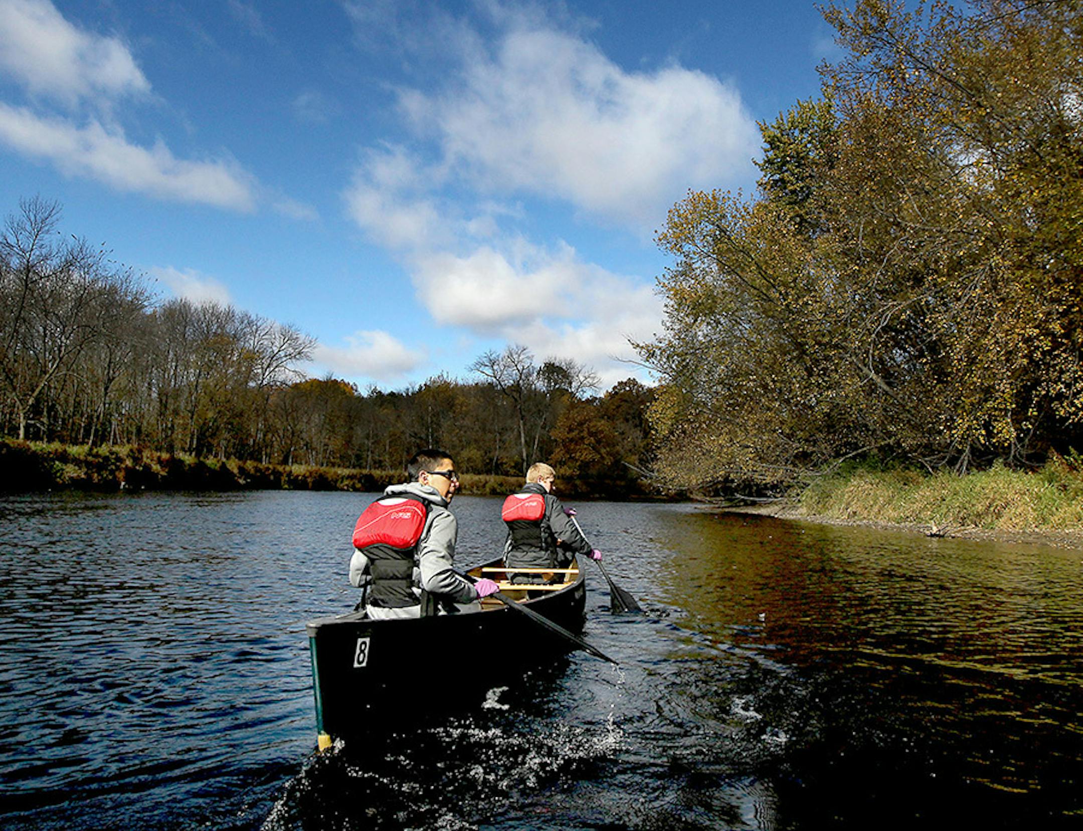 Takoda Prep students Jordan Deegan, left, and Max Fauble paddled in a canoe to find spots to plant wild rice seeds along the Rum River, Tuesday, October 13, 2015 near Cambridge, MN.