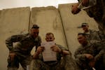 U.S. Army Cpl. Sean Morton, 25, from Boston, Mass., left, and a comrade assigned to Killer Troop, 3rd Squadron, 3rd Armored Cavalry Regiment, consult 