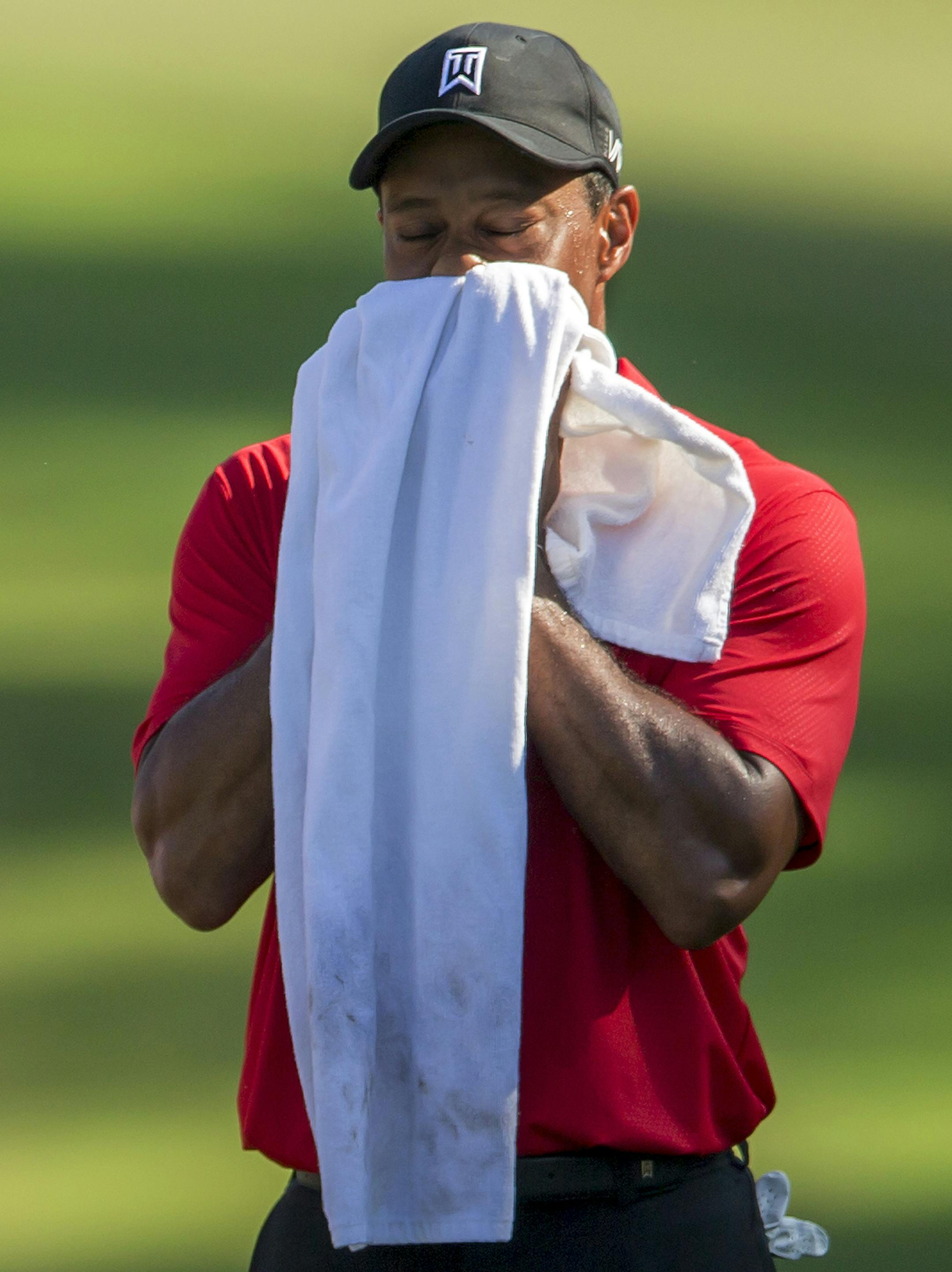 Tiger Woods wipes his face on the 15th fairway during the final round of the Wyndham Championship golf tournament at Sedgefield Country Club in Greensboro, N.C., Sunday, Aug. 23, 2015. (AP Photo/Rob Brown)