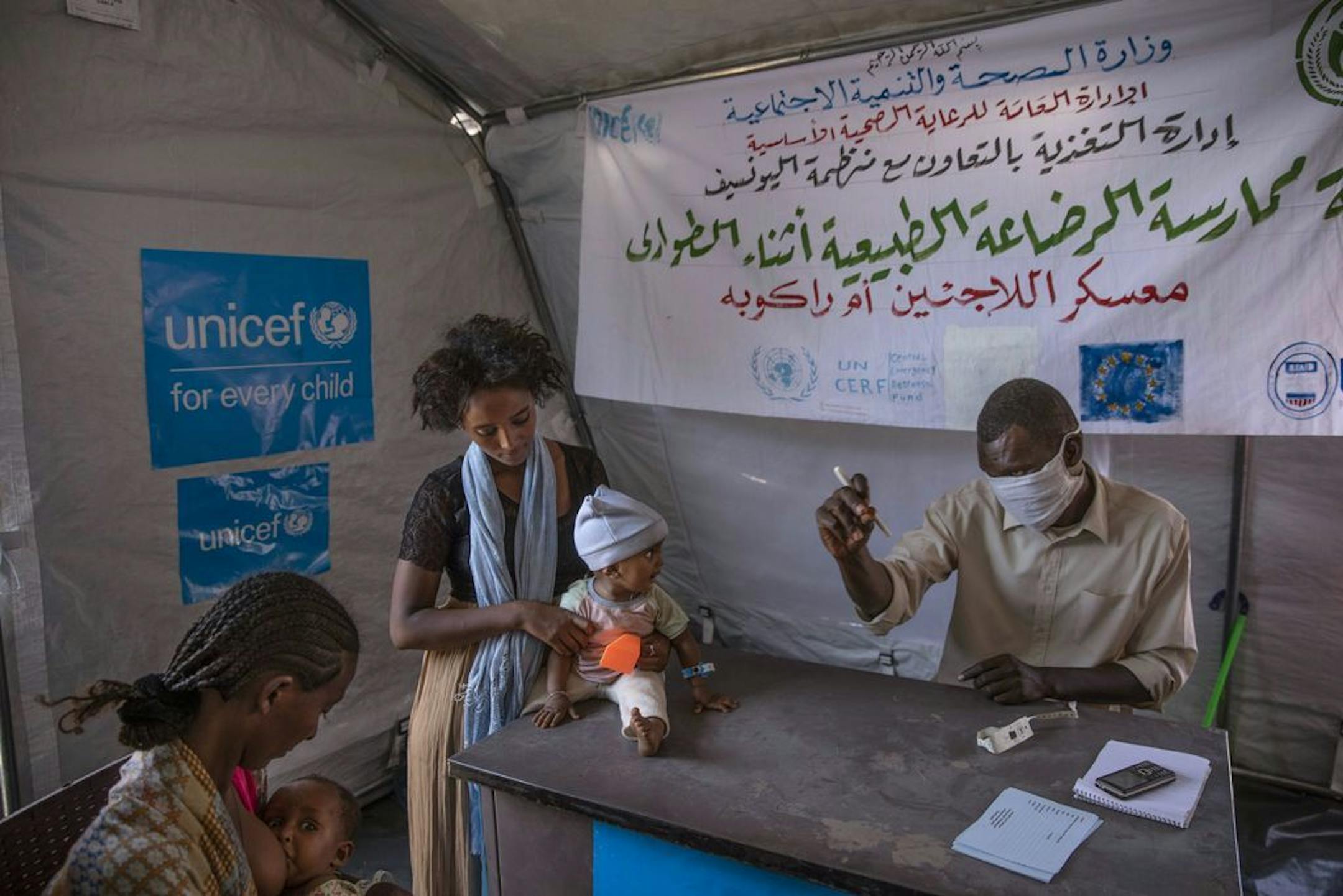Tigray women who fled the conflict in Ethiopia's Tigray region, take shelter inside a UNICEF tent, as Filippo Grandi, U.N. High Commissioner for Refugees, visits Umm Rakouba refugee camp in Qadarif, eastern Sudan, Saturday, Nov. 28, 2020.