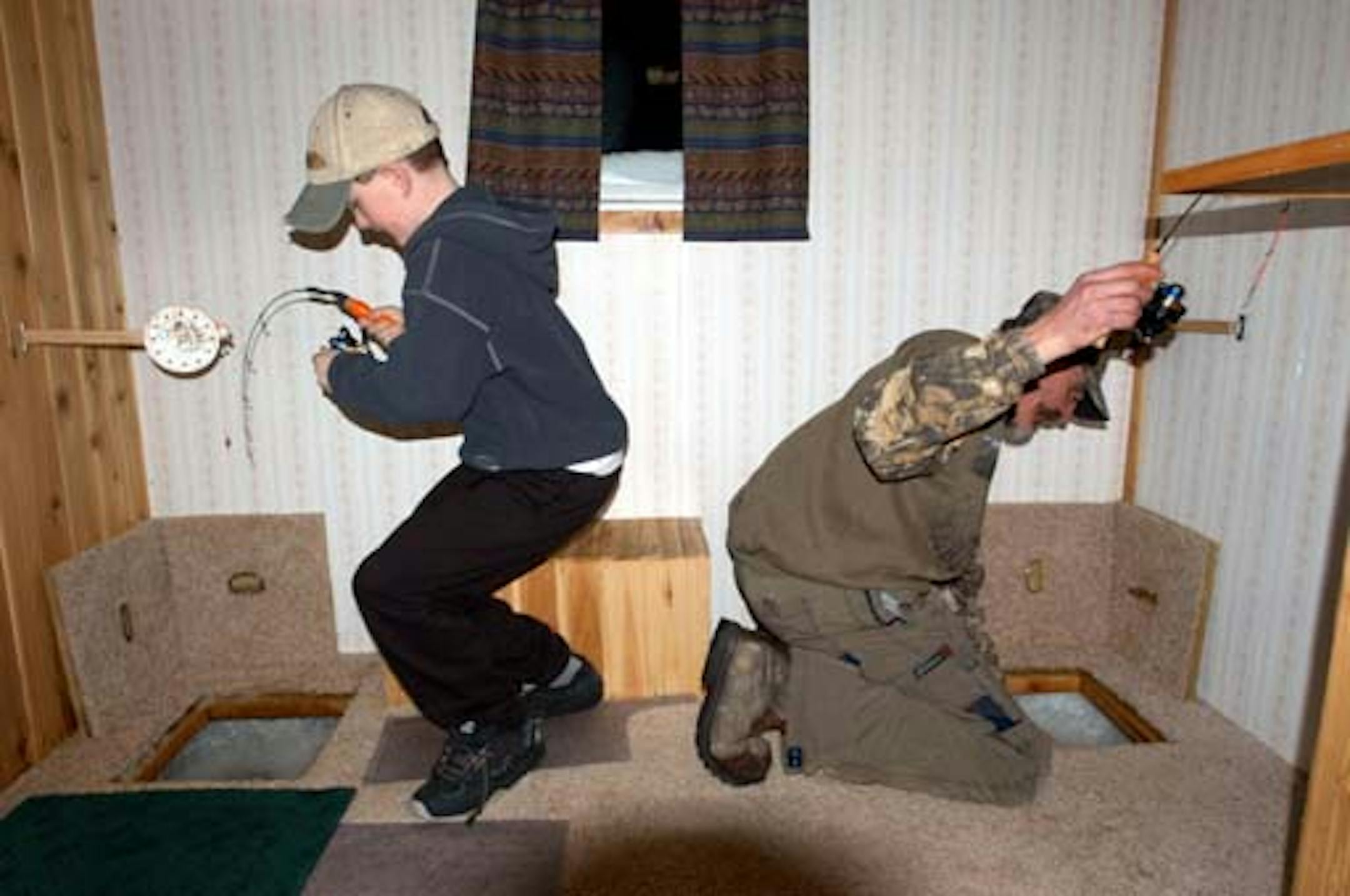 ~- photos by Dennis Anderson for his "Outdoors" column Sun Feb 8, 2004, page C14, about crappie fishing on Upper Red Lake, Minnesota. Shown here are Trevor Anderson (at left) and Spider Johnson (right) in a deluxe fish house built by Doug "Governor" Lovander.