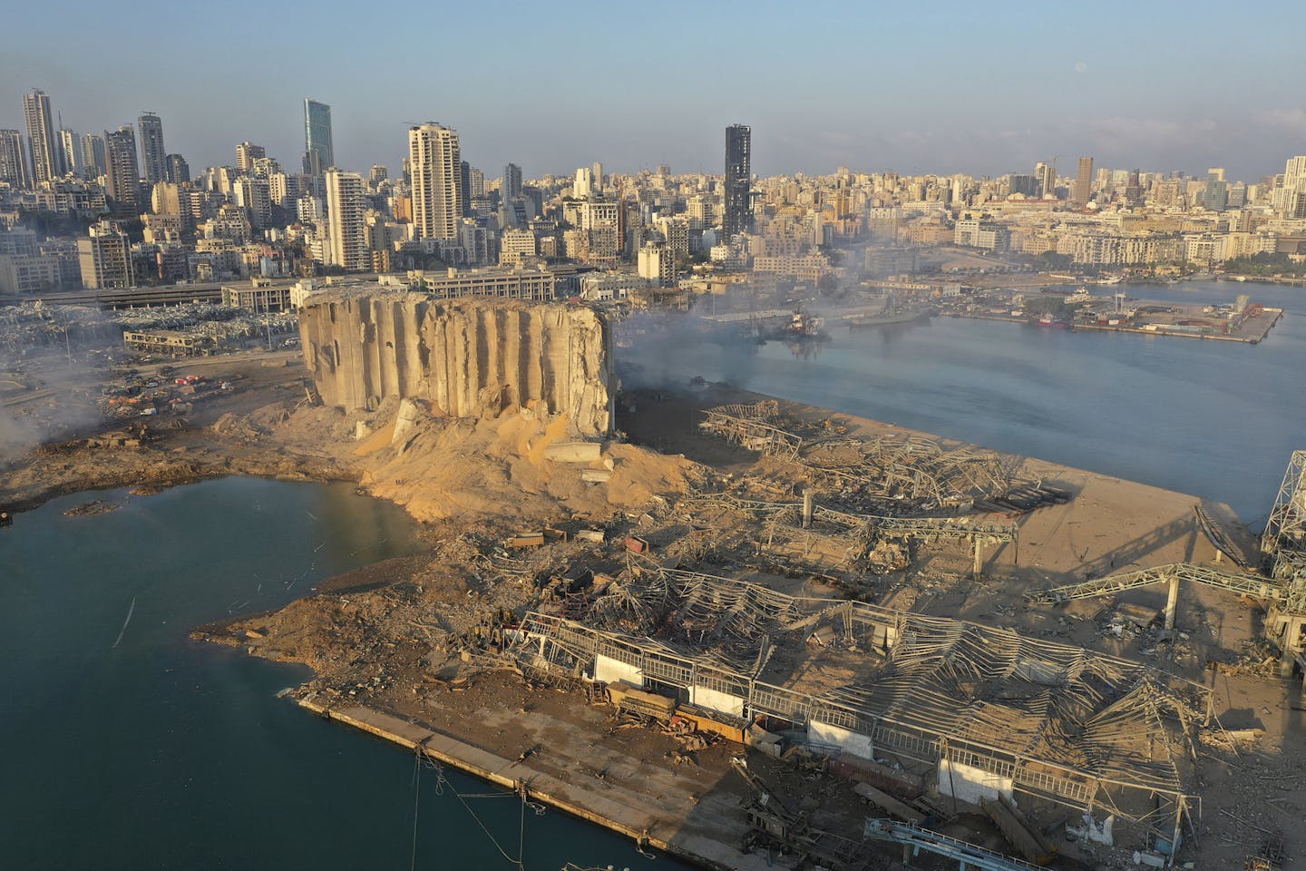 A drone picture shows the scene of an explosion that hit the seaport of Beirut, Lebanon, Wednesday, Aug. 5, 2020. A massive explosion rocked Beirut on Tuesday, flattening much of the city's port, damaging buildings across the capital and sending a giant mushroom cloud into the sky. (AP Photo/Hussein Malla)