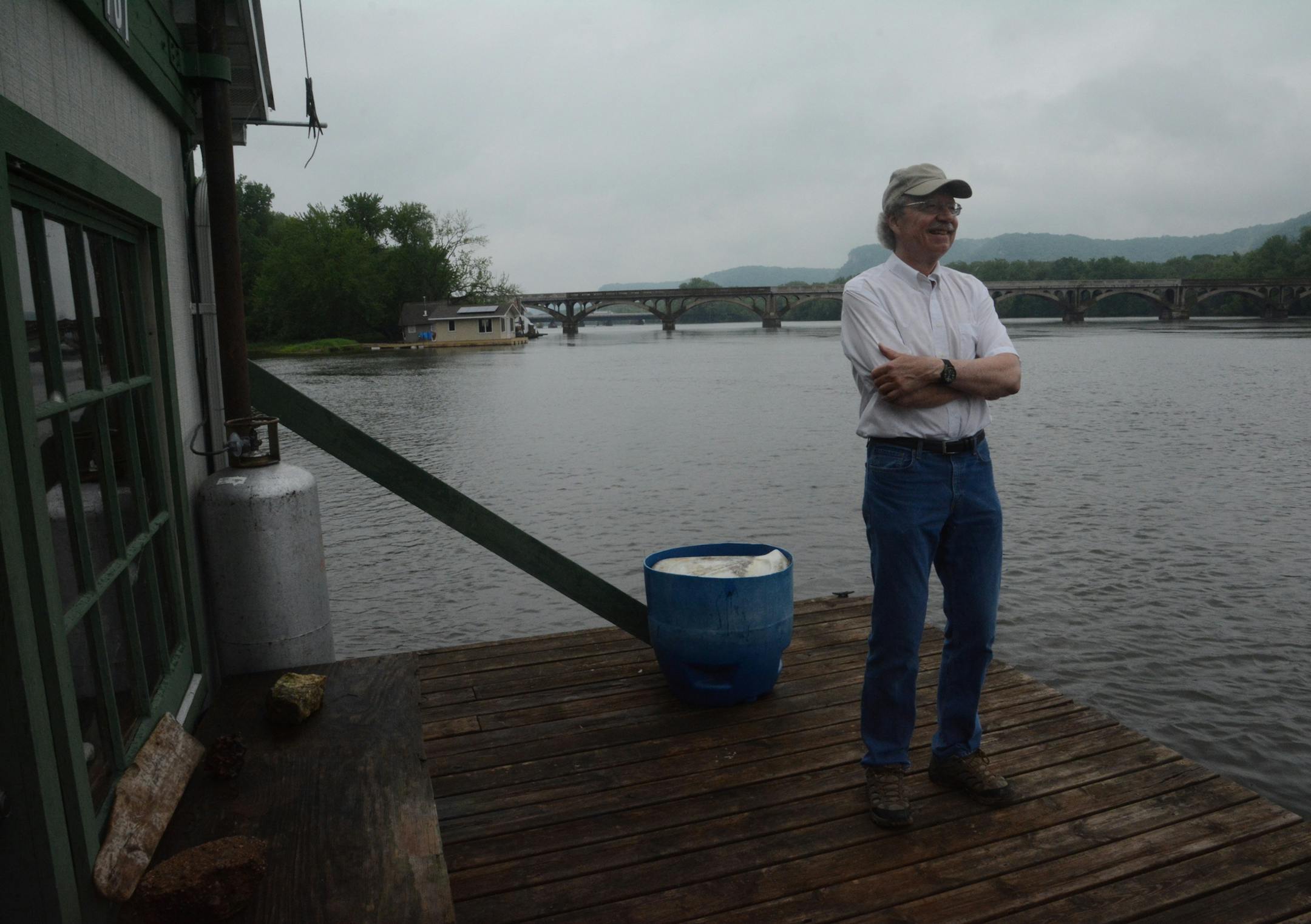 Reggie McLeod stands on a house boat on the Mississippi River at Latch Island in Winona, Minn.