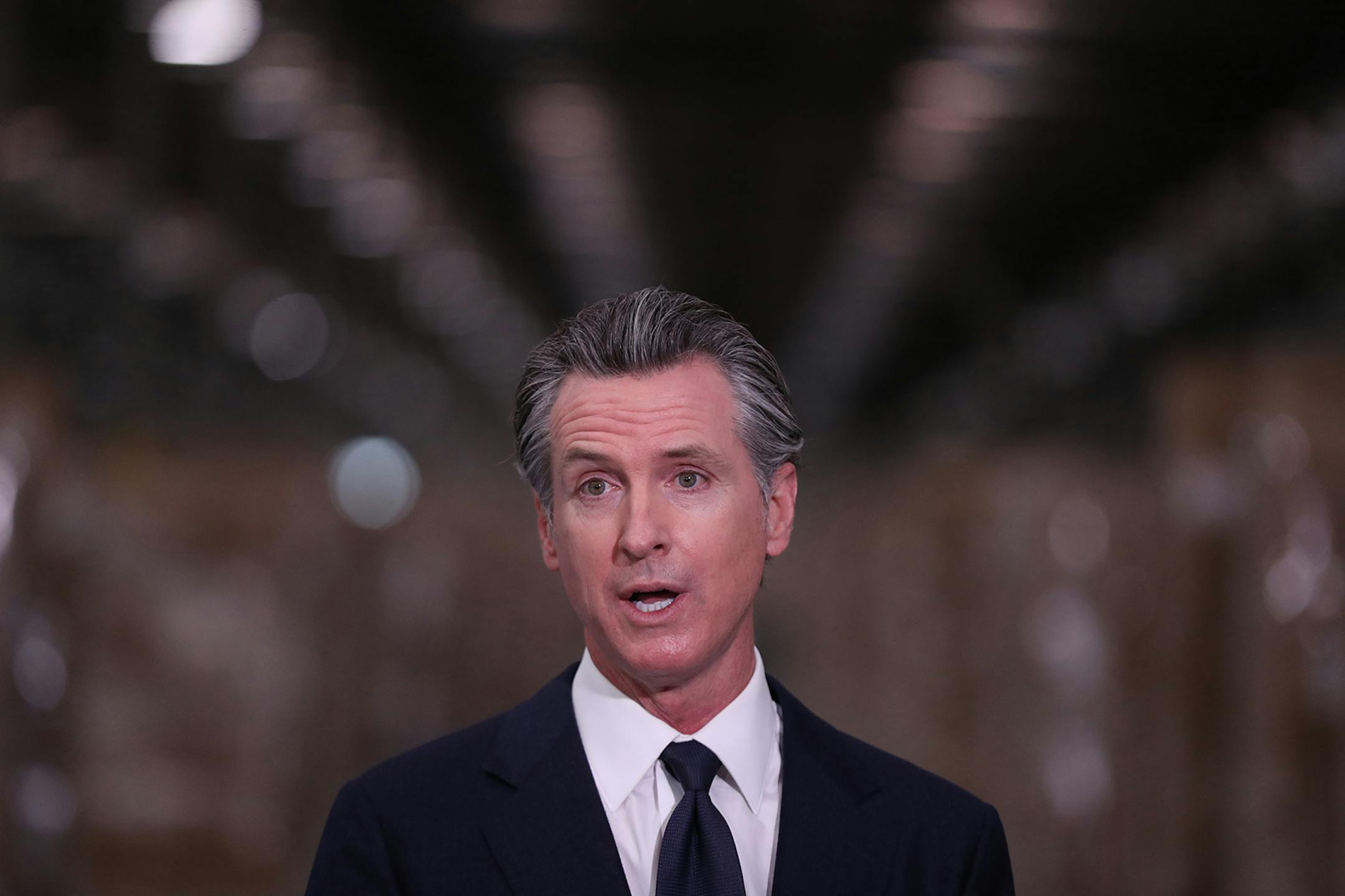 Gov. Gavin Newsom speaks during a press conference to unveil the next phase of California's pandemic response in the UPS Healthcare warehouse filled with personal protective equipment in Fontana, California, on Feb. 17, 2022. (Allen J. Schaben/Los Angeles Times/TNS) ORG XMIT: 42696401W