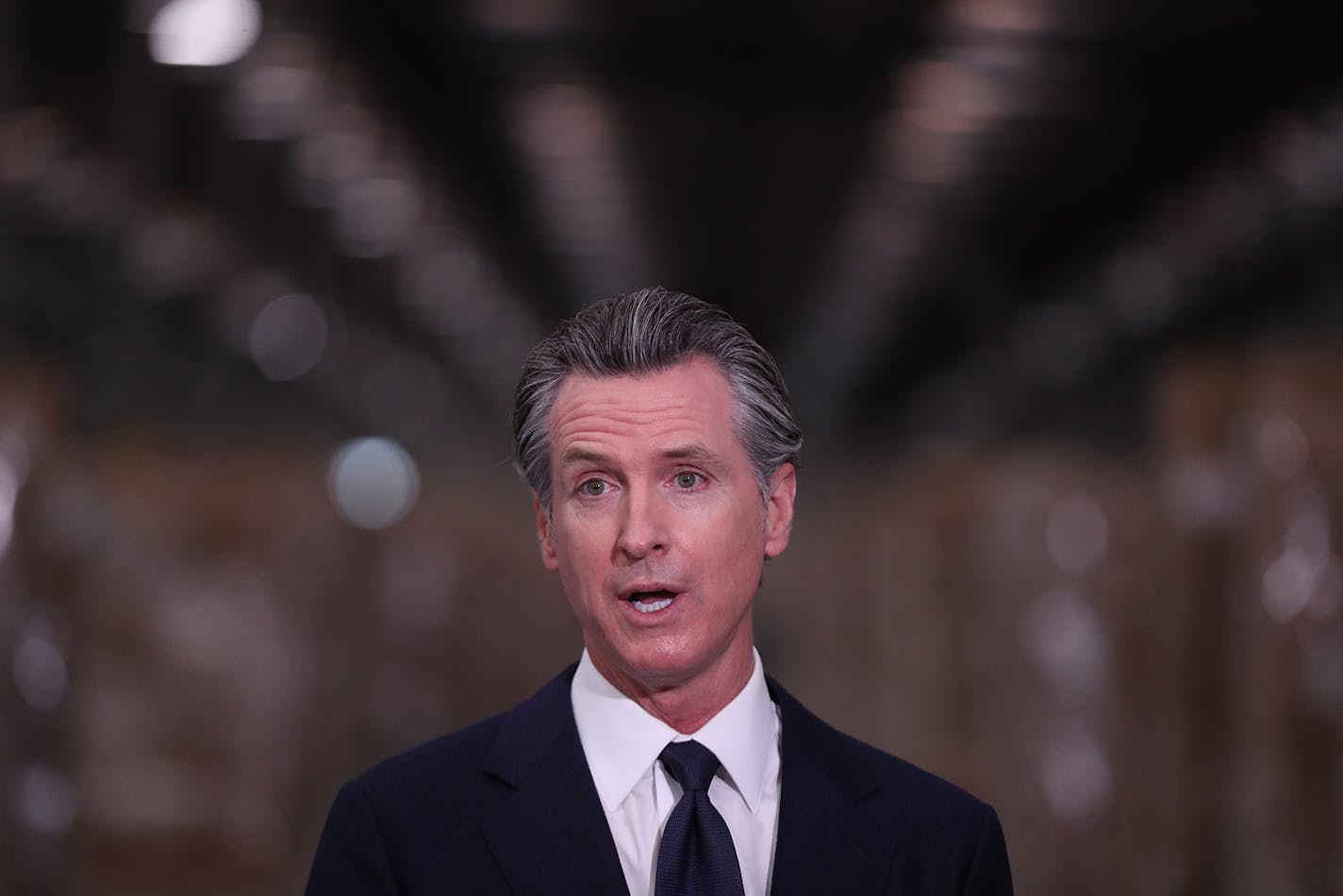 Gov. Gavin Newsom speaks during a press conference to unveil the next phase of California's pandemic response in the UPS Healthcare warehouse filled with personal protective equipment in Fontana, California, on Feb. 17, 2022. (Allen J. Schaben/Los Angeles Times/TNS) ORG XMIT: 42696401W