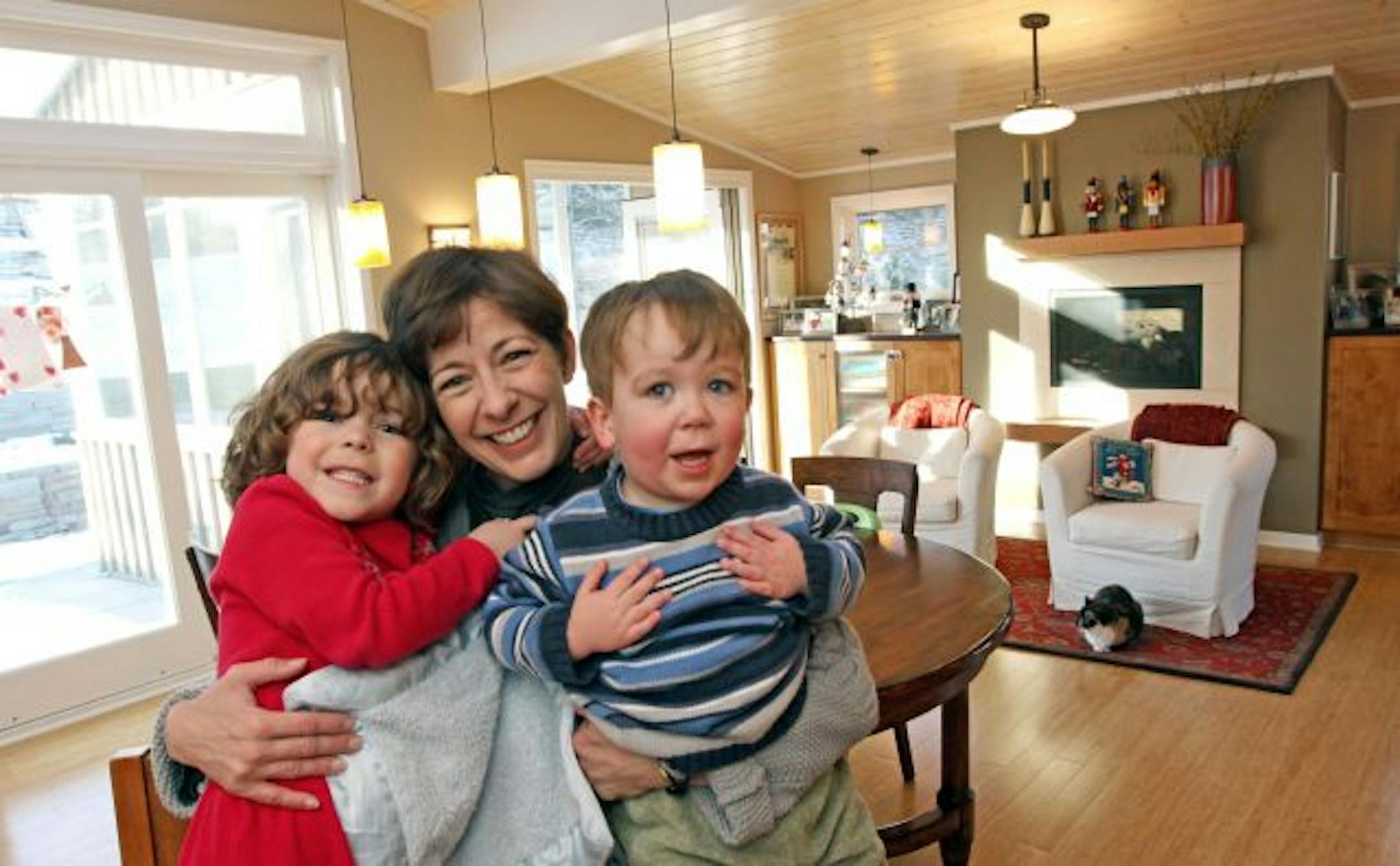 Lauri Kraft posed with Jamie, 4, and Jason, 2, in the Kraft's dining and family room, which they remodeled with double-pane windows, bamboo floors and reused timber. "It sets a good example for our kids. It makes a healthier home for us. And I am happy that we kept a few things out of the landfill," Lauri Kraft said.
