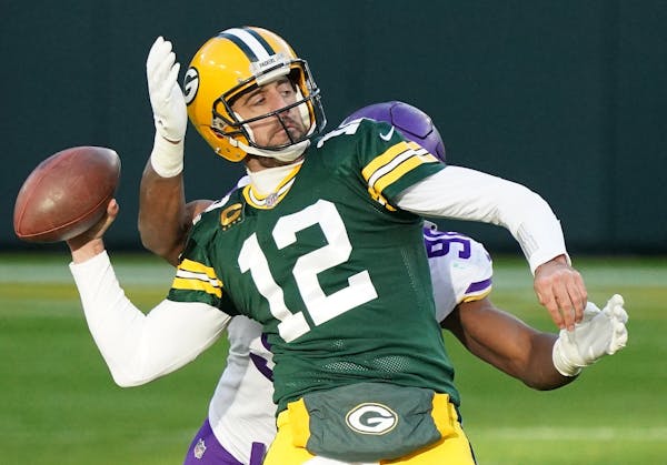 Green Bay Packers quarterback Aaron Rodgers (12) looked to make a long touchdown pass as Minnesota Vikings defensive end D.J. Wonnum (98) went in for 