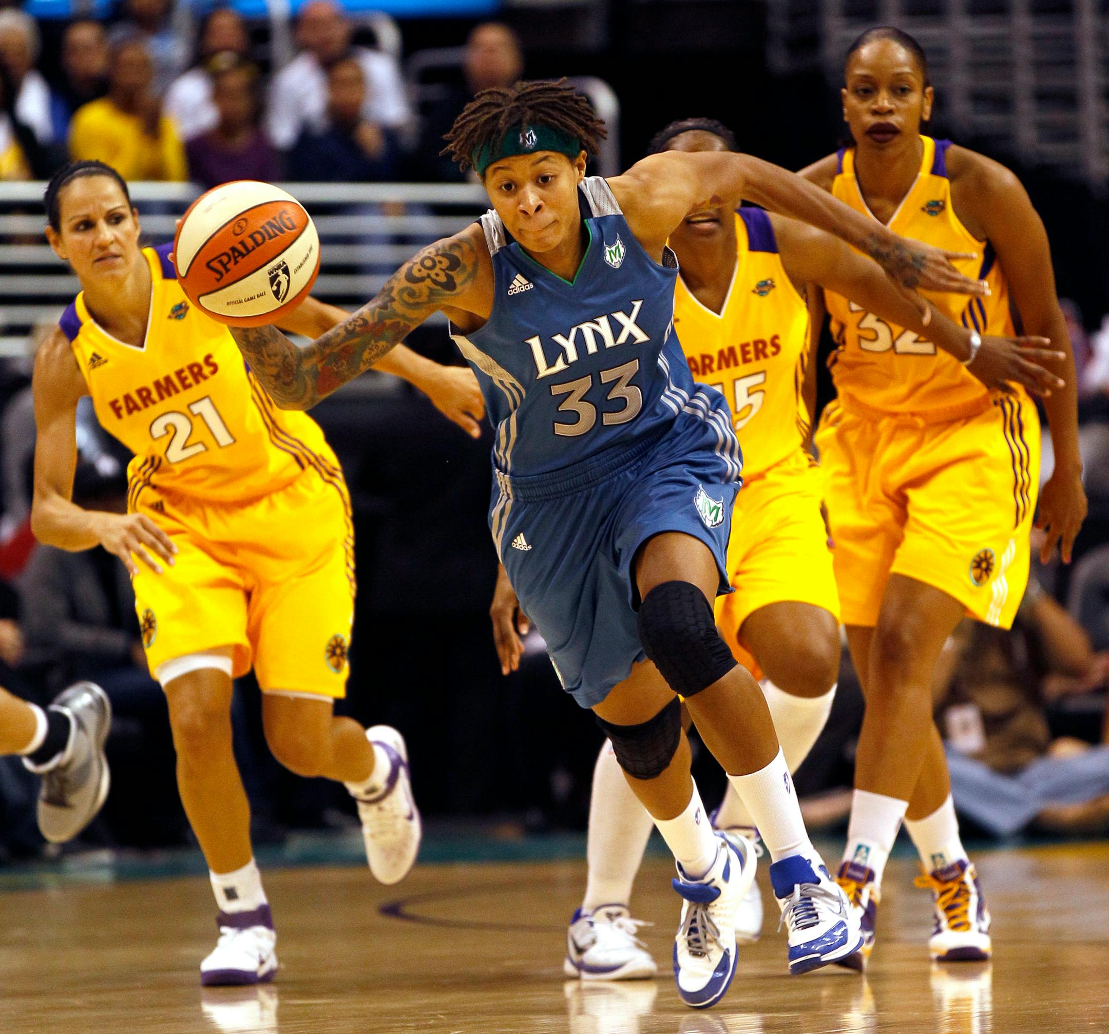 Minnesota Lynx's Seimone Augustus (33) steals the ball as Los Angeles Sparks guard Ticha Penicheiro (21) watches during the first quarter of a WNBA basketball game in Los Angeles, Friday, June 3, 2011. (AP Photo/Lori Shepler)