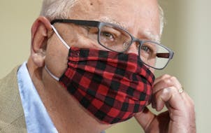 Minnesota Gov. Tim Walz wore his buffalo plaid cloth mask at a July 22 news conference. He thanked Minnesotans on Monday for a recent hike in mask-wea