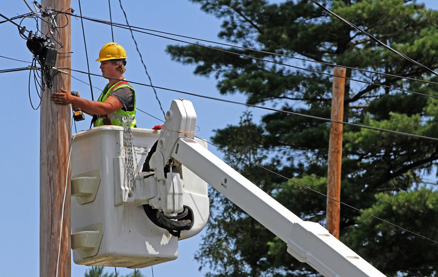 Seth Kern, with Lake States Construction, a sub-contractor of Lake Connections, readied telephone poles in Two Harbors to string stainless steel strand cables from which fiber optic cable will be lashed to on 7/31/12. By the time the communications project is done in 2014 around 2000 miles of fiber optic cable will be strung, connecting customers with broadband internet, video and telephone service. ] Bruce Bisping/Star Tribune bbisping@startribune.com ORG XMIT: MIN2014022618253324