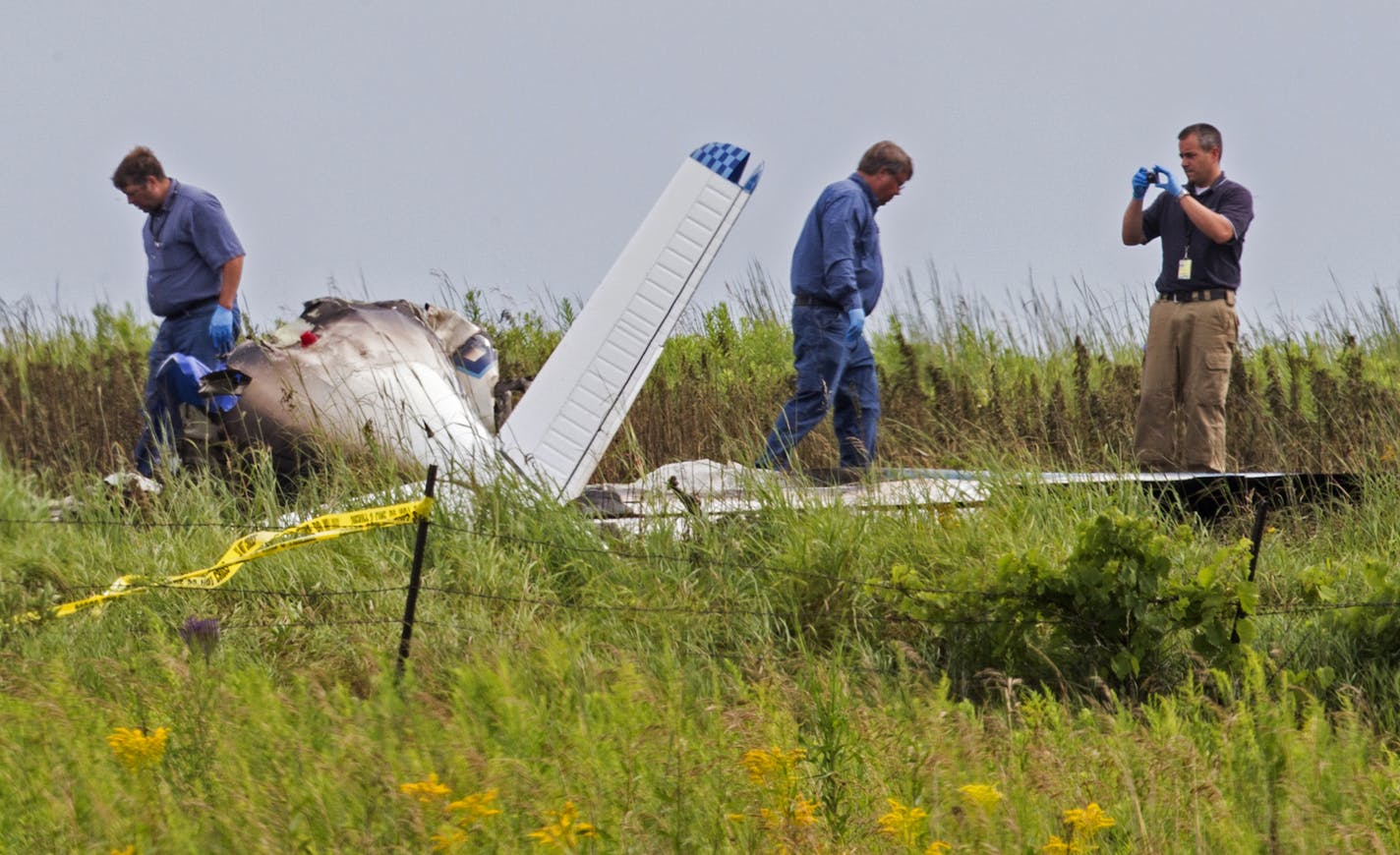 Officials investigate the site of a plane crash in Alden Township, southwest of Amery, Wis. on Tuesday, July 28, 2015. ] LEILA NAVIDI leila.navidi@startribune.com / BACKGROUND INFORMATION: Four people died Monday evening when their plane crashed in a field southwest of Amery, Wis. The plane is a Beech M35, a six-passenger, single-engine aircraft, according to a Federal Aviation Administration official. ORG XMIT: MIN1507281057530588