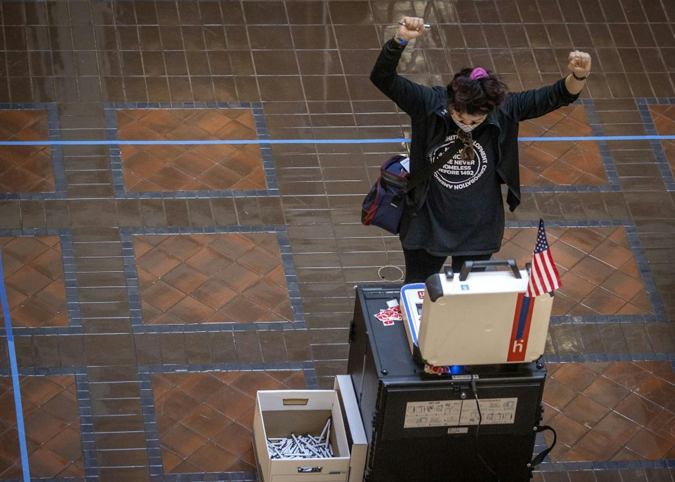 Jess Grams cheered after she watched her ballot go through the ballot box after she voted at the Landmark Center Tuesday.