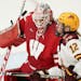 Minnesota Golden Gophers forward Grace Zumwinkle (12) tracked the puck in front of Wisconsin Badgers goaltender Kristen Campbell (35) in the third per