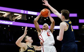 Oklahoma guard Jeremiah Fears (0) drives to the basket between Michigan forward Will Tschetter, left, and center Danny Wolf during a game in December.