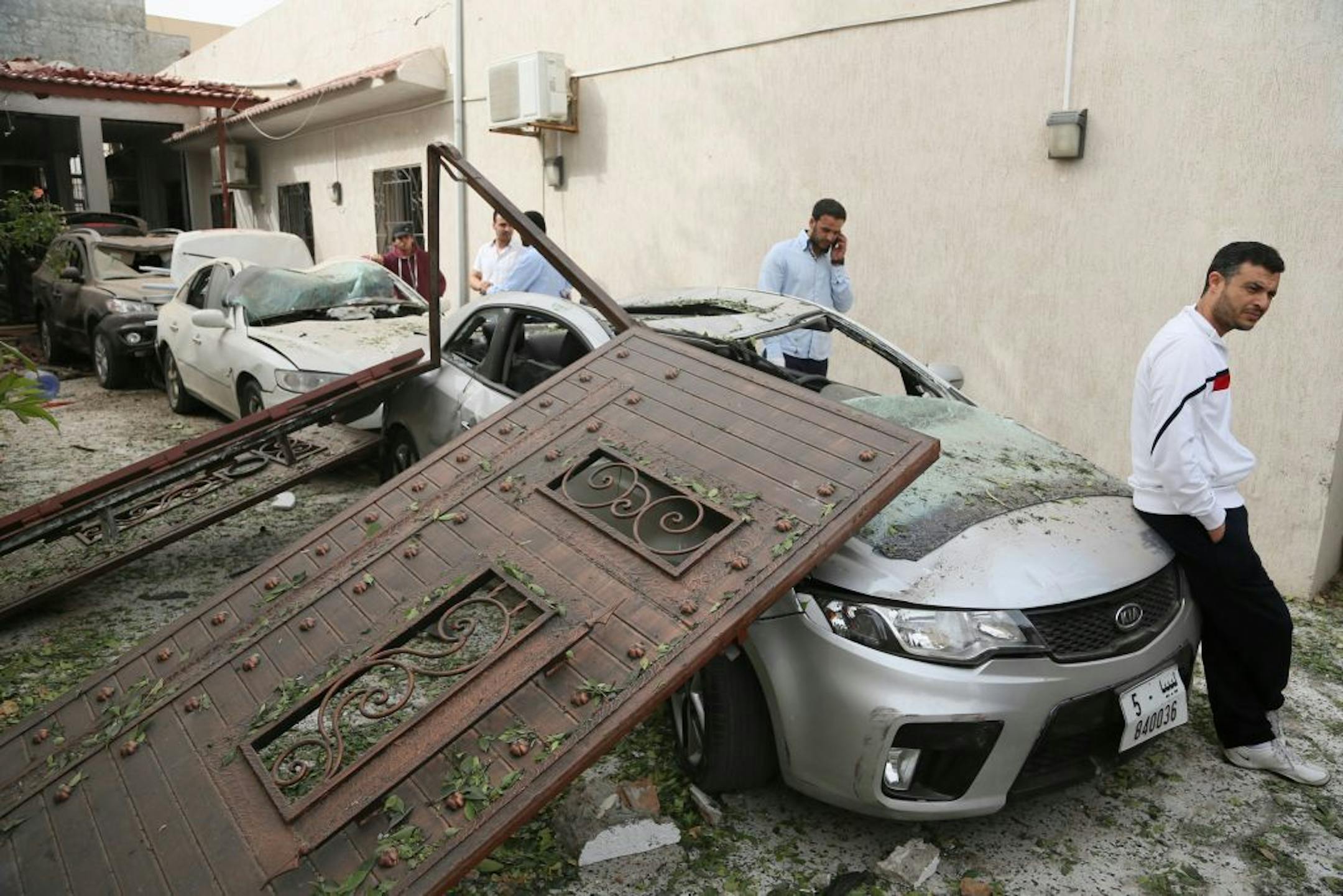 Damaged cars are seen at the site of a car bomb that targeted the French embassy wounding two French guards and causing extensive material damage in Tripoli, Libya, Tuesday, April 23, 2013. An explosives-laden car was detonated just outside the embassy building in Tripoli's upscale al-Andalus neighborhood, officials said.