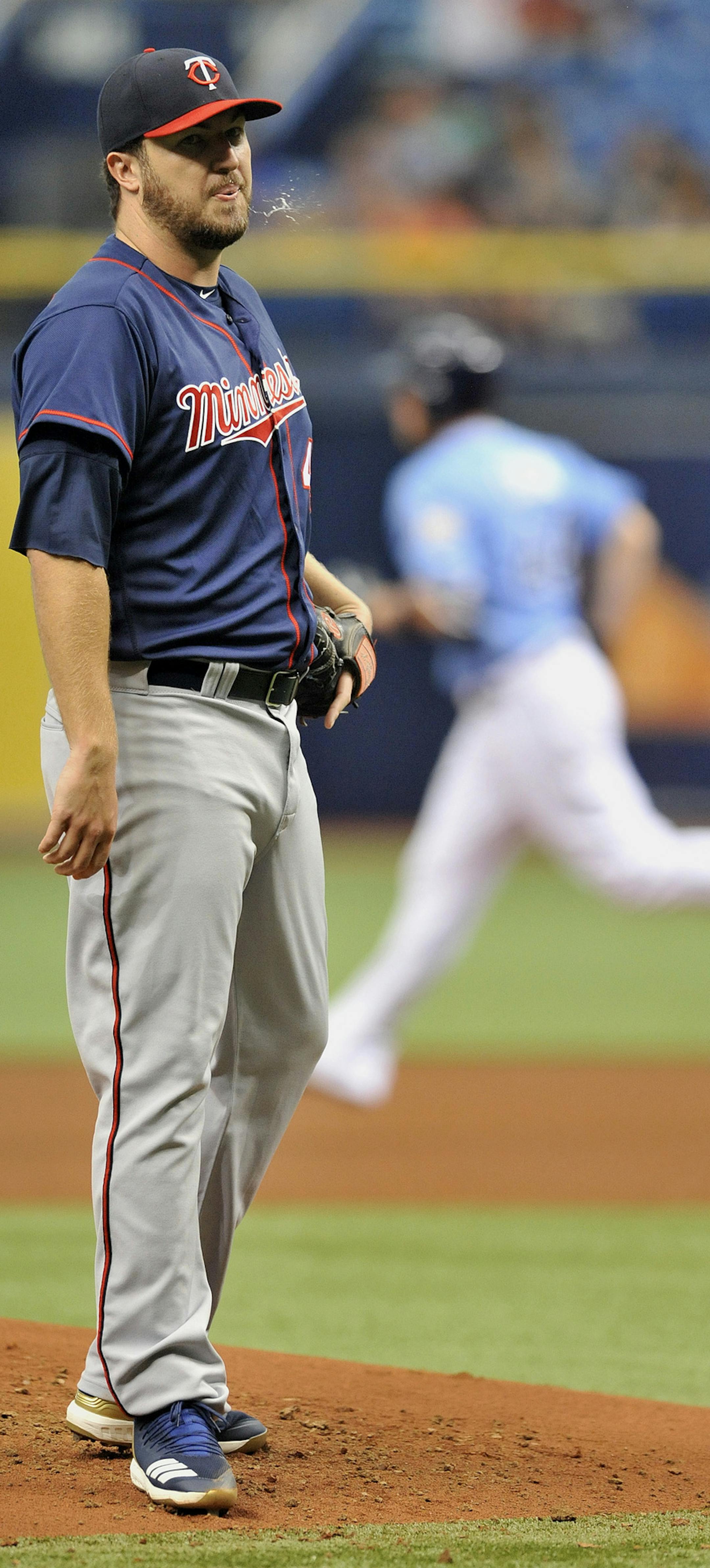 Minnesota Twins starter Phil Hughes spits off the mound as Tampa Bay Rays' C.J. Cron, right, circles the bases after hitting a two-run home run during the first inning of a baseball game Sunday, April 22, 2018, in St. Petersburg, Fla. (AP Photo/Steve Nesius)