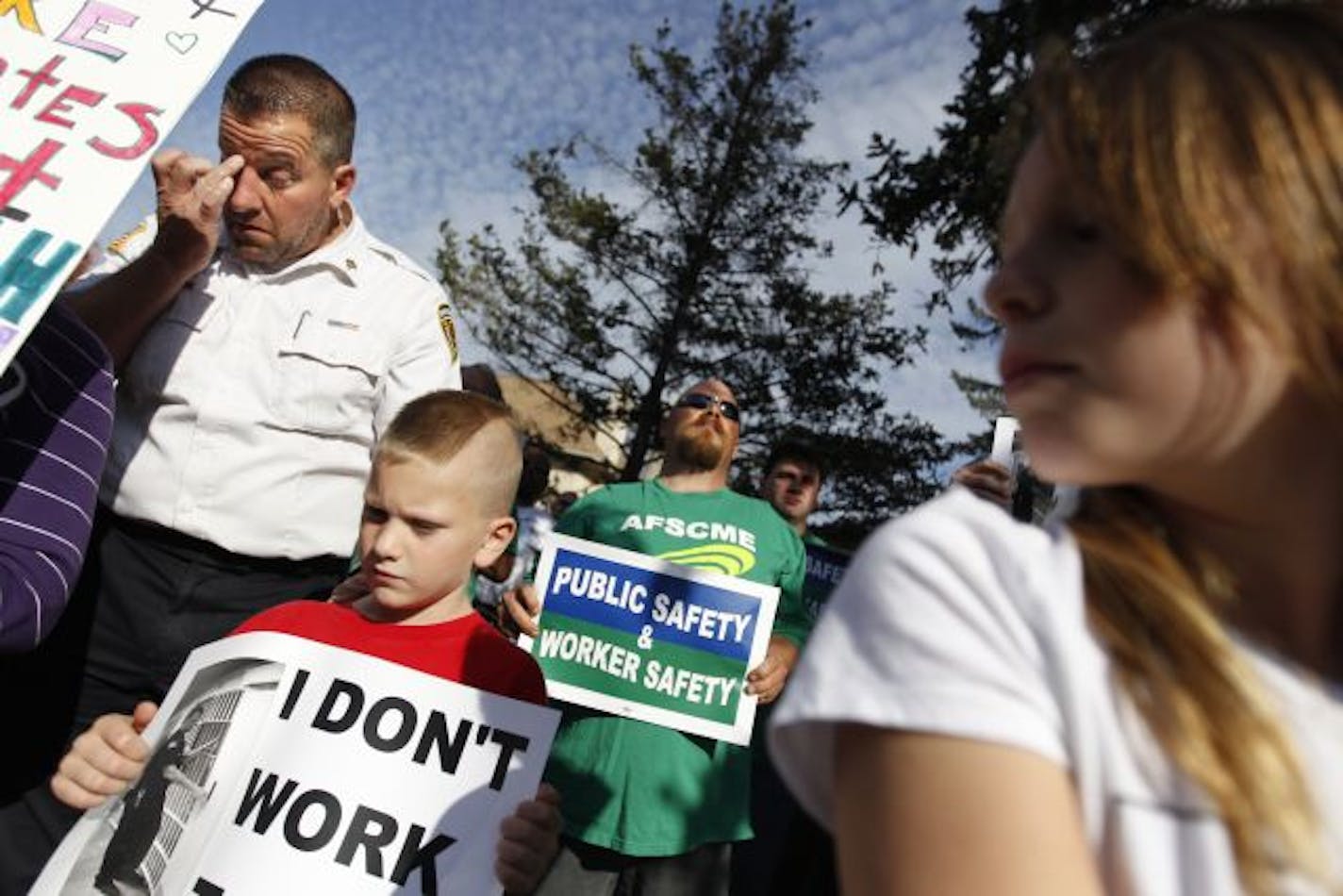 Corrections Sgt. Paul Gorder became emotional at a rally outside Stillwater prison on Tuesday to protest the cuts over staffing at three Minnesota correctional facilities. His son Alex, 7, held a sign that read, "I don't work to die." His daughter Ashley, 10, is at right.