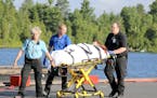 A camper is attended to by ambulance staff after arriving Thursday, July 21, 2016 in Ely, Minn., by floatplane from the Boundary Waters Canoe Area Wil