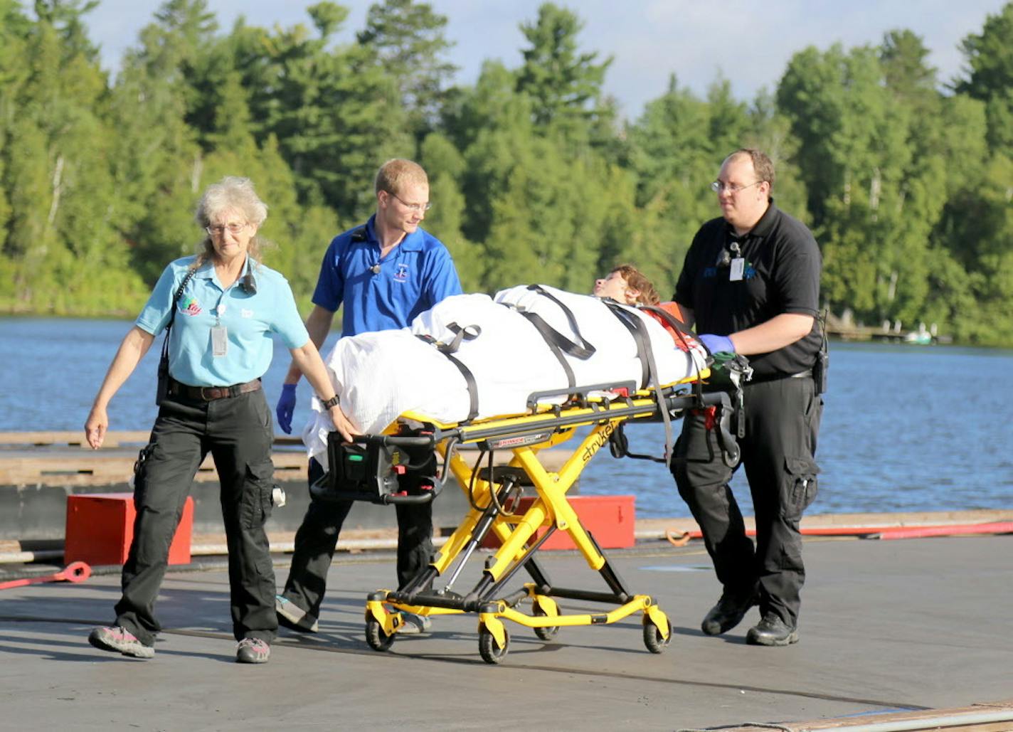 A camper is attended to by ambulance staff after arriving Thursday, July 21, 2016 in Ely, Minn., by floatplane from the Boundary Waters Canoe Area Wilderness after being injured following a severe storm that knocked trees down on Basswood Lake. The injured party received non-life threatening injuries and was treated at the Ely-Bloomenson Community Hospital. A boy and a woman camping with a Boy Scouts adventure program were killed and two other campers were injured when severe storms swept throug