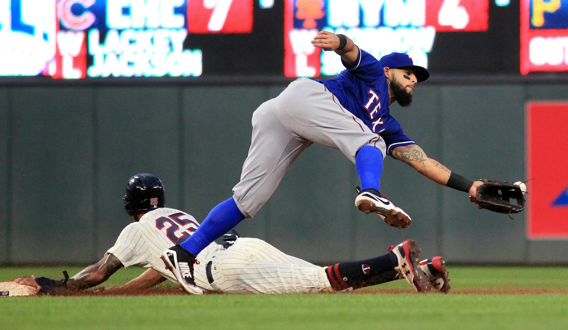 Texas Rangers second baseman Rougned Odor (12) misses a catch as Minnesota Twins' Byron Buxton (25) slides in on a steal during the fifth inning of a baseball game Saturday, Aug. 5, 2017, in Minneapolis. The Rangers won 4-1. (AP Photo/Andy Clayton-King)