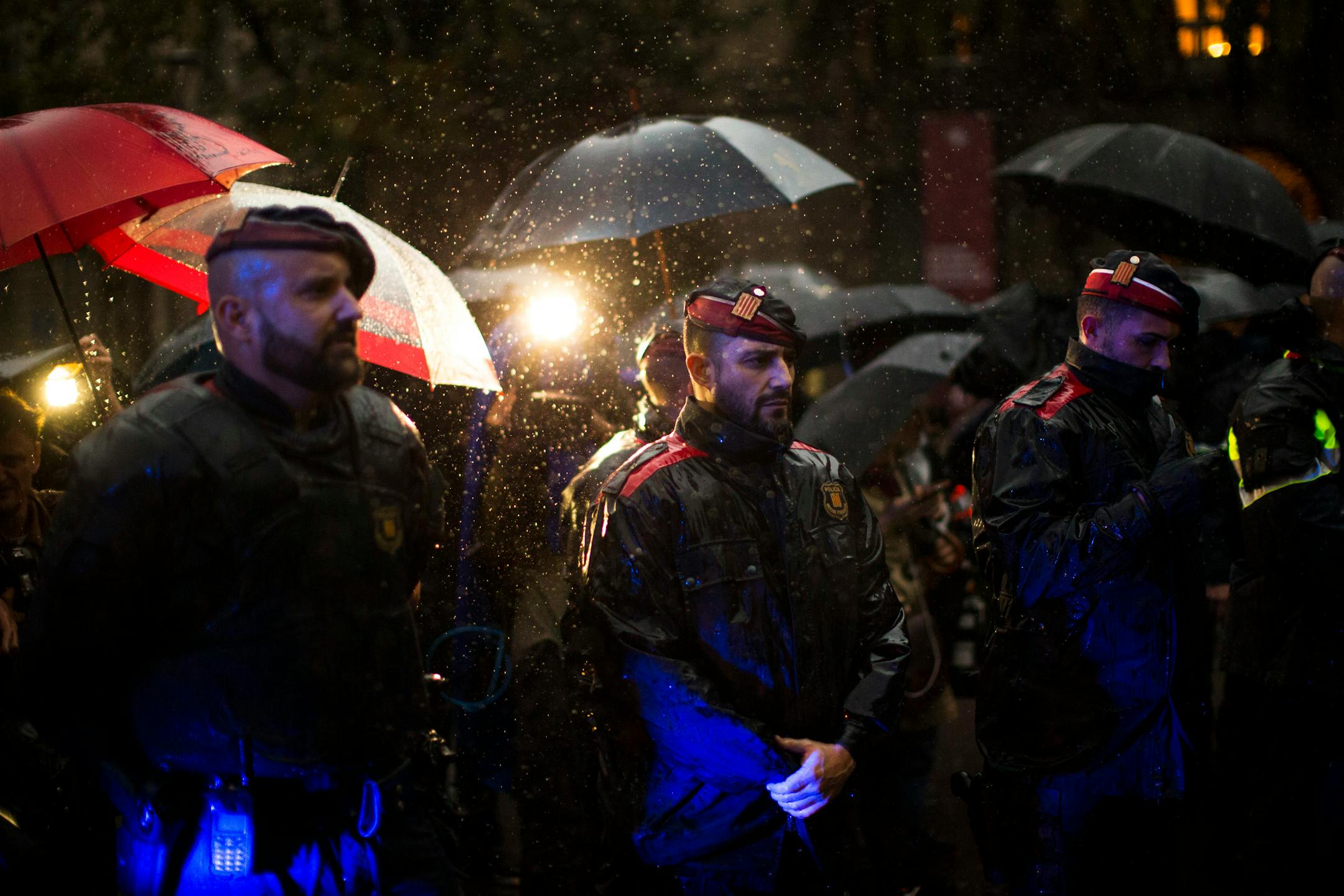 Catalan police officers cordon off the area as protesters gather at the gates of the Spanish central government offices in Barcelona to protest against the National Court's decision to imprison civil society leaders, Spain, Thursday, Oct. 19, 2017. A National Court judge ordered the preventive jailing of ANC's Jordi Sanchez and Omnium's Jordi Cuixart for allegedly orchestrating protests in mid-September that hindered a judicial probe into preparations for the Oct. 1 referendum that has been deem