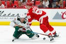 Red Wings defenseman Danny DeKeyser (65) checked Wild right winger Mikael Granlund as he tried to shoot in the third period Thursday.