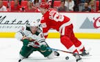 Red Wings defenseman Danny DeKeyser (65) checked Wild right winger Mikael Granlund as he tried to shoot in the third period Thursday.