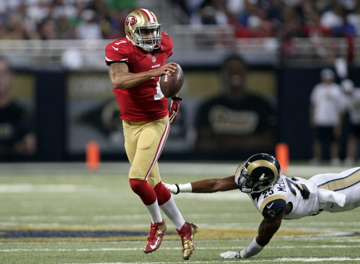 San Francisco 49ers quarterback Colin Kaepernick, left, eludes St. Louis Rams safety T.J. McDonald during the third quarter of an NFL football game in 2015.