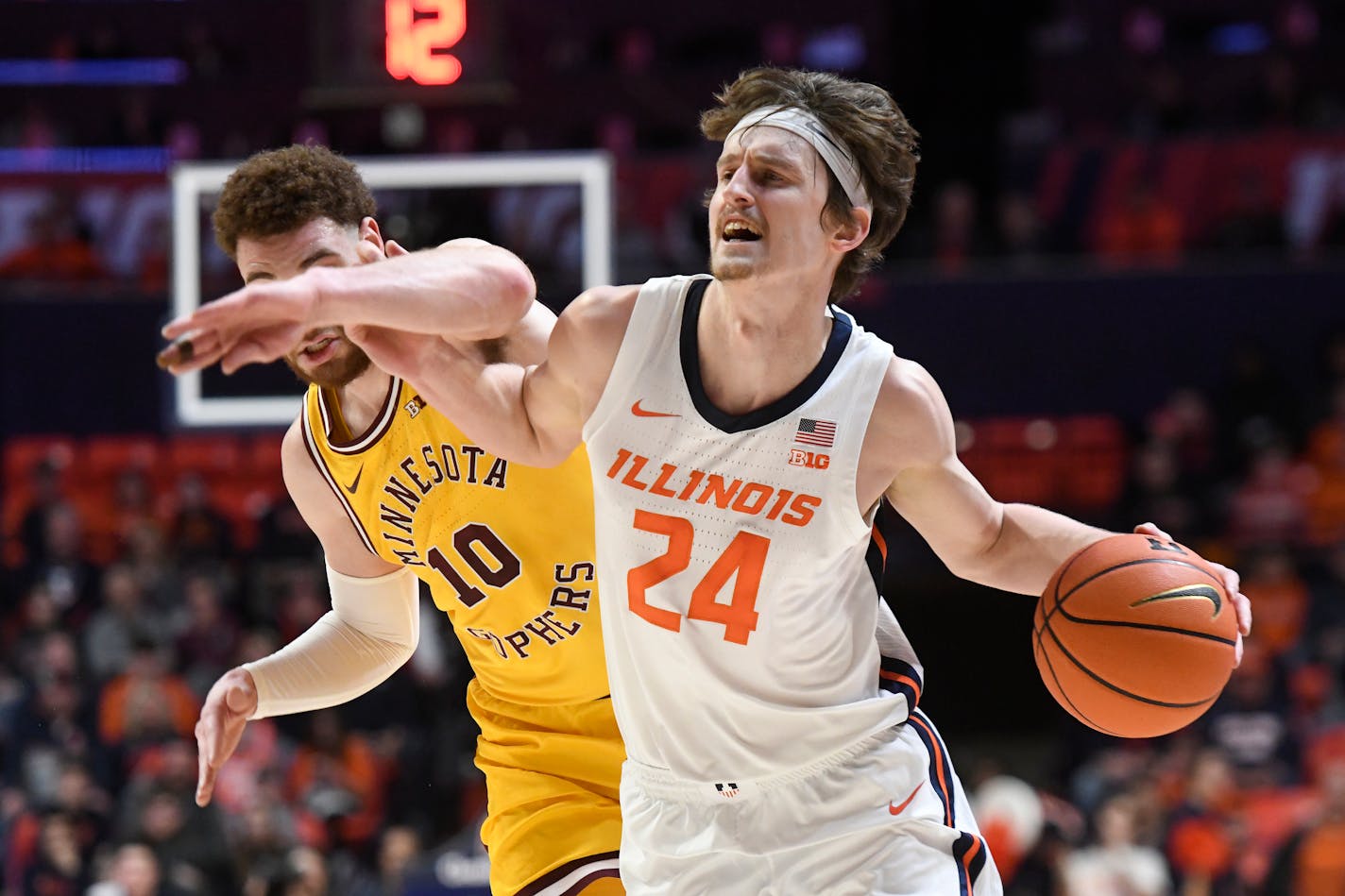 Illinois' Matthew Mayer (24) works the ball inside against Minnesota's Jamison Battle (10) during the first half of an NCAA college basketball game, Monday, Feb. 20, 2023, in Champaign, Ill. (AP Photo/Michael Allio)