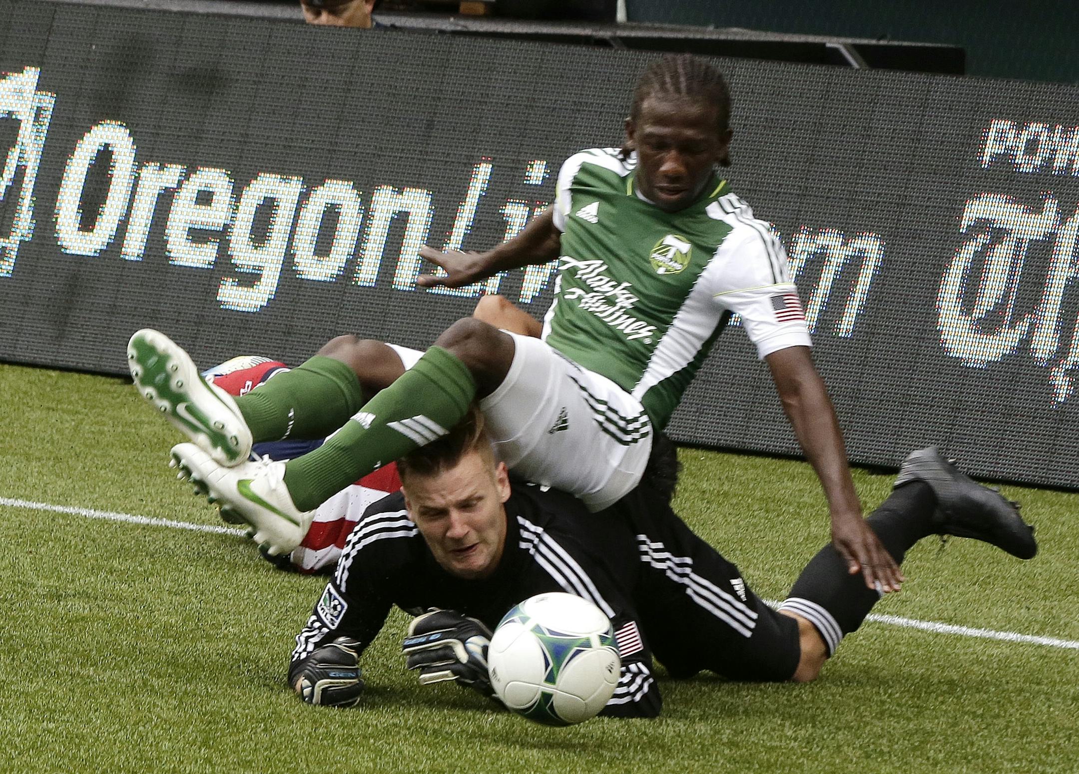 Chivas USA goalie Patrick McLain, bottom, dives to get the ball as Portland Timbers midfielder Diego Chara falls on top of him during the second half of an MLS soccer game in Portland, Ore., Sunday, May 12, 2013. The Timbers won 3-0.(AP Photo/Don Ryan)