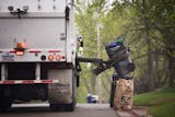 A GarbageMan worker empties containers onto the truck on trash pickup day in Bloomington between France Avenue and Normandale Boulevard on Thursday, May 7, 2015.