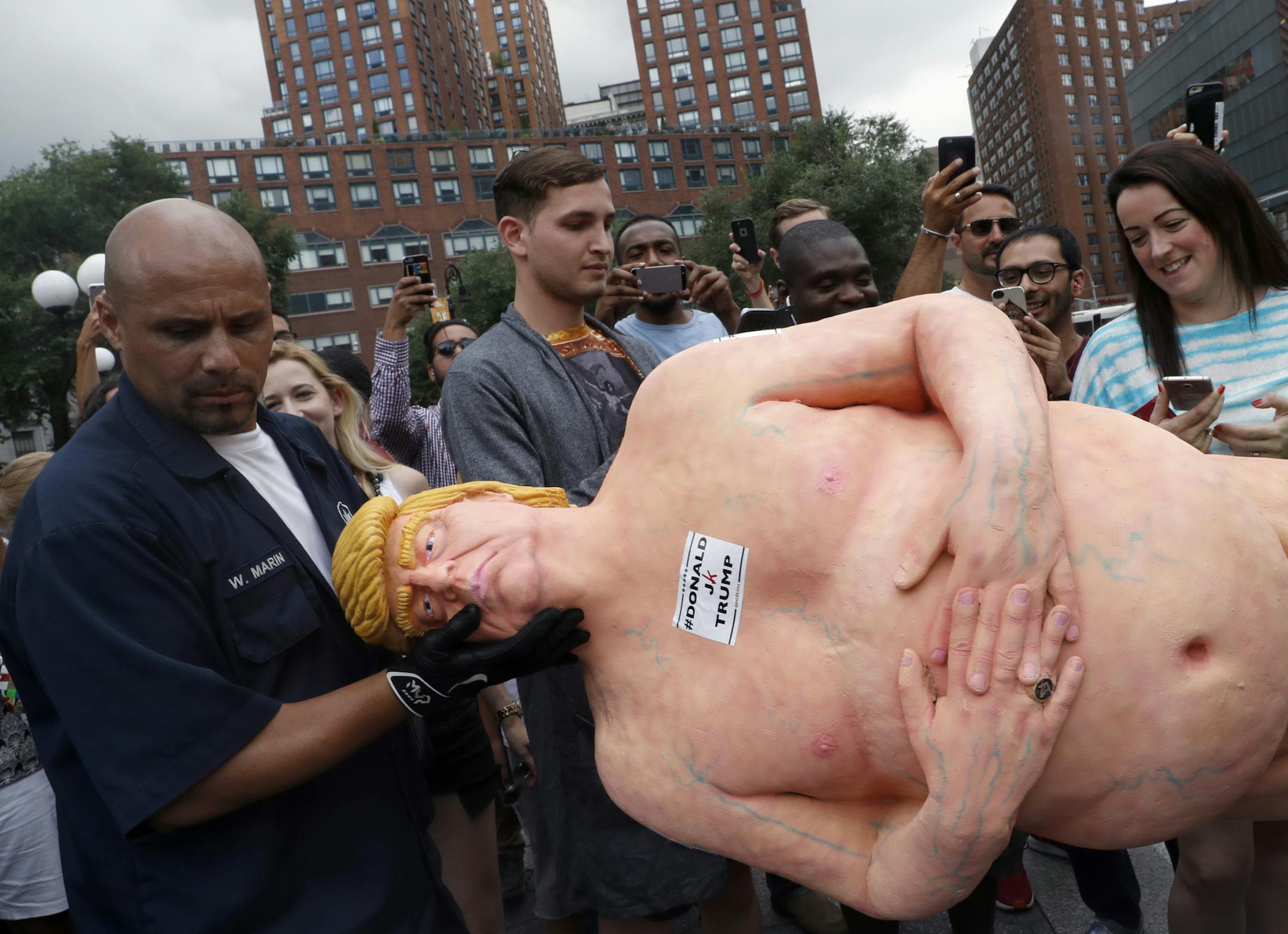 An employee of the New York City Department of Parks & Recreation removes a statue of a naked Republican presidential candidate Donald Trump, Thursday, Aug. 18, 2016 in New York's Union Square. (AP Photo/Mary Altaffer)