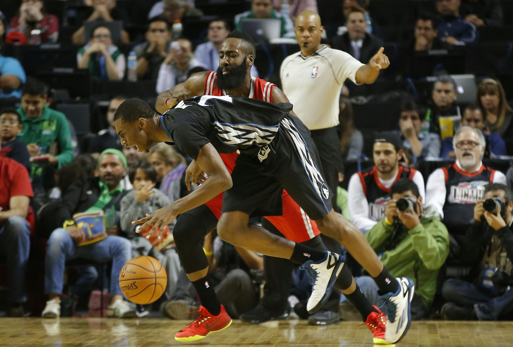Minnesota Timberwolves' Andrew Wiggins (22) is fouled by Houston Rockets' James Harden (13) during the first half of an NBA basketball game in Mexico City, Wednesday, Nov. 12, 2014. (AP Photo/Eduardo Verdugo)