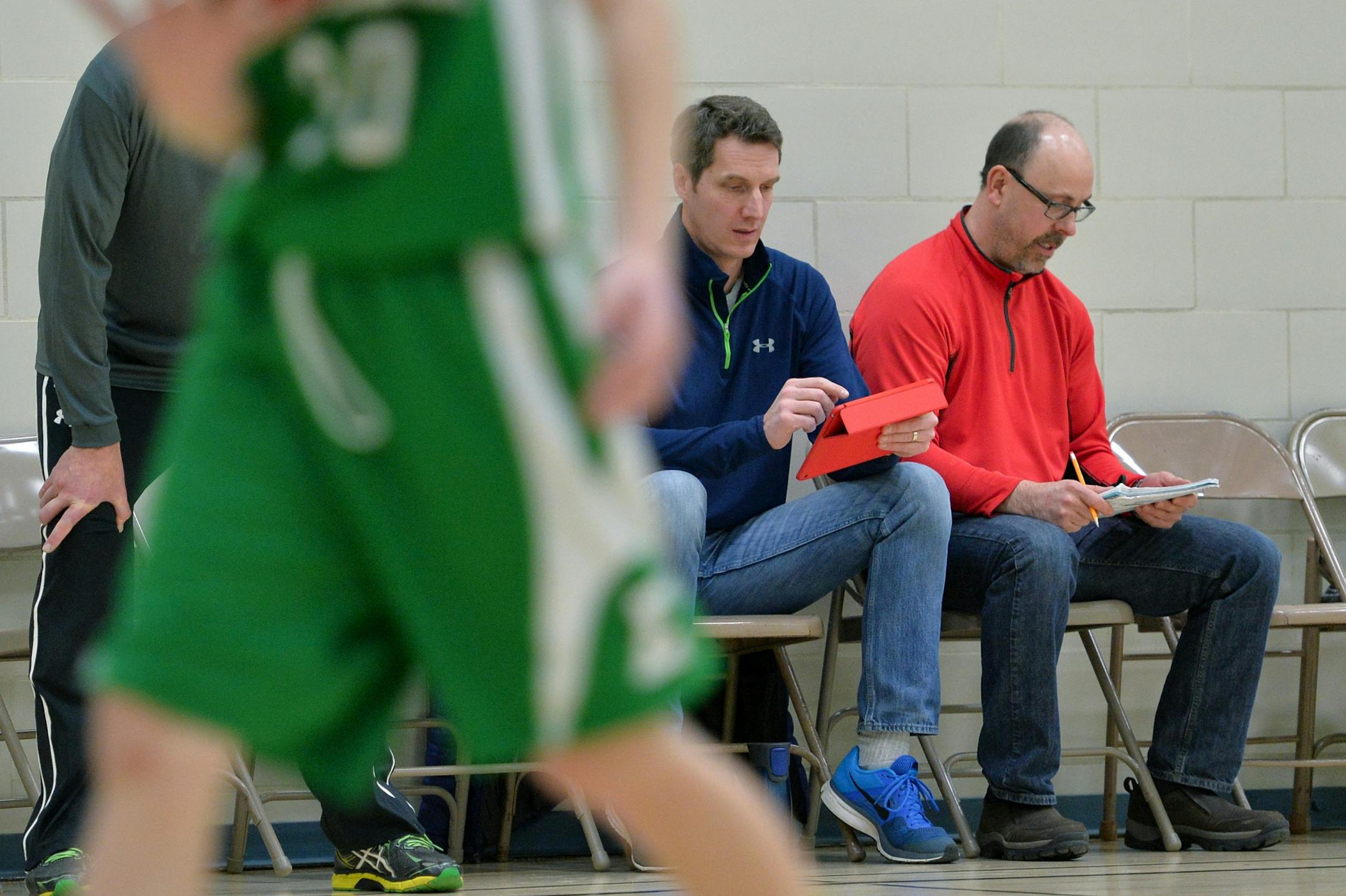 Edina's 4A traveling boys' basketball team parents, Mike Munson records player statistics into an iPad using the app, iScore while Steve Curry documents the data on paper.