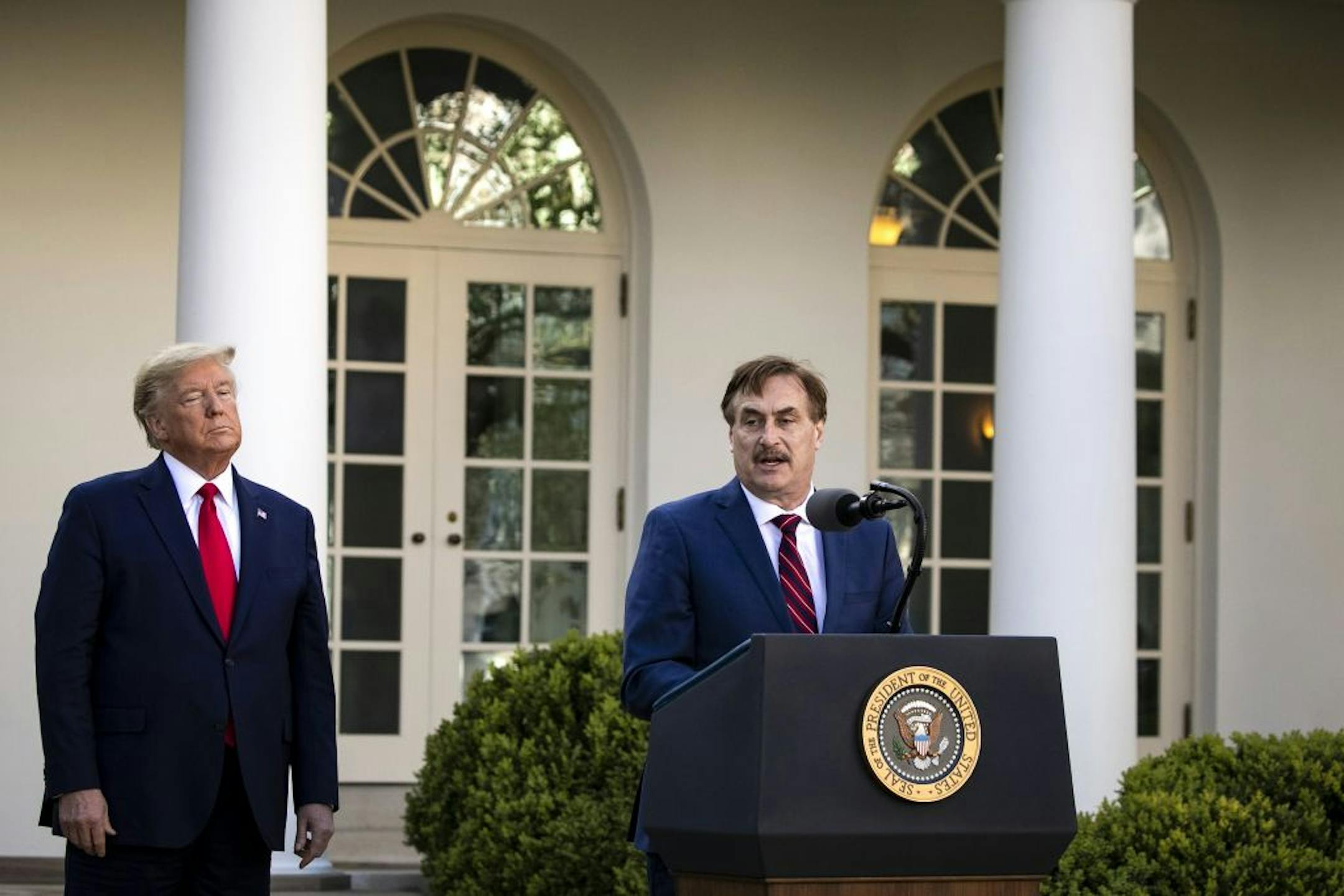 FILE -- President Donald Trump listens as Mike Lindell, My Pillow CEO, speaks from the Rose Garden of the White House on March 30, 2020. Lindell, a Trump donor, claims oleandrin is a miracle cure for COVID-19 but no studies have shown that it is safe or effective, and the shrub it's derived from is poisonous.