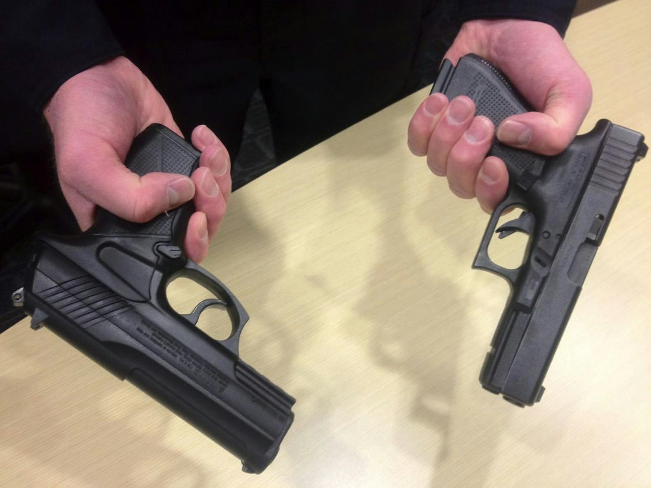 At a glance, Airsoft guns look like the real thing. A real Hopkins police handgun is on the right.