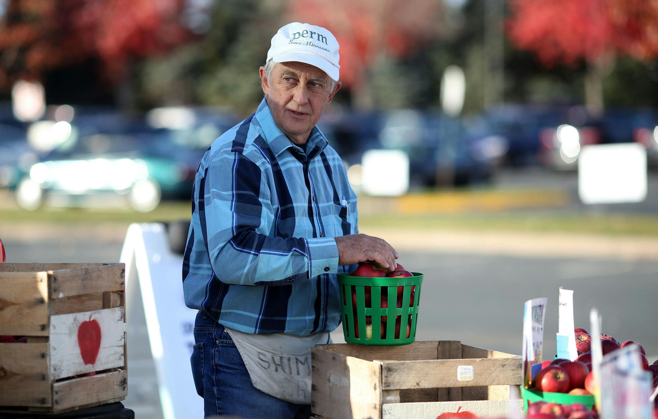 Ron Shimanski, of Shimanski Orchards restocked his display with a new crate of apples. ] (KYNDELL HARKNESS/STAR TRIBUNE) kyndell.harkness@startribune.com At the Maple Grove farmers' market inMaple Grove Min., Thursday, October 16, 2014.