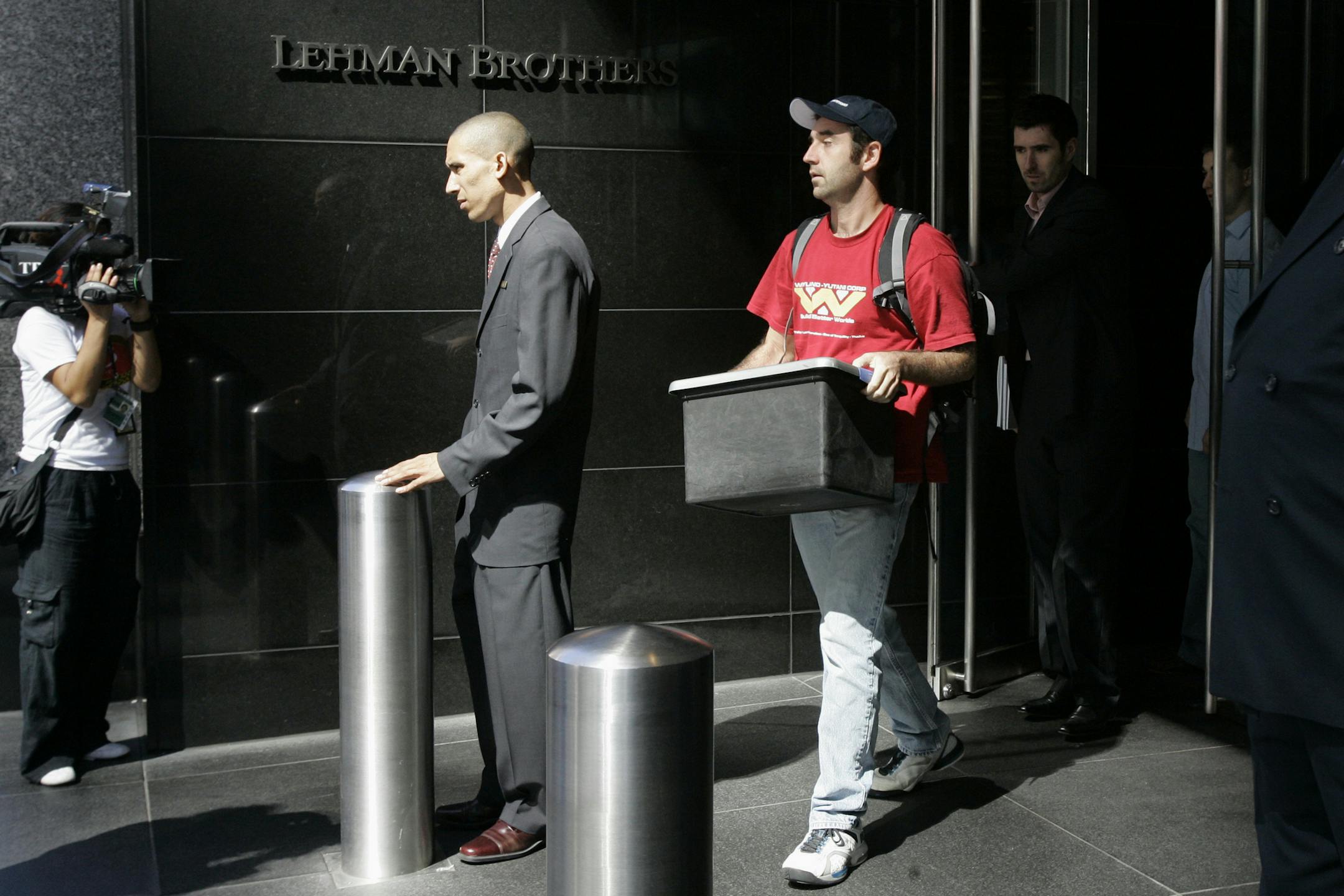 FILE- In this Sept. 15, 2008, file photo a man leaves the Lehman Brothers headquarters carrying a box in New York. Lehman Brothers, a 158-year-old investment bank choked by the credit crisis and falling real estate values, filed for Chapter 11 protection. Home prices had sunk, and foreclosure notices began arriving. Layoffs began to spike. Tremors intensified as Lehman Brothers, a titan of Wall Street, slid into bankruptcy on Sept. 15, 2008. (AP Photo/Mary Altaffer, File)