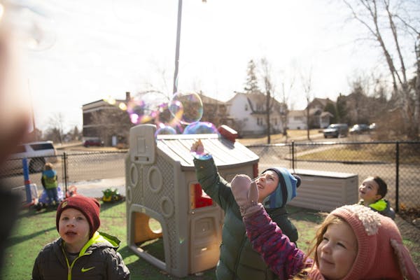 (Left) Silas, Elias and Nola jumped up to try and pop bubbles during outdoors playtime at Aunty's Child Care in Duluth, MN on Thursday.