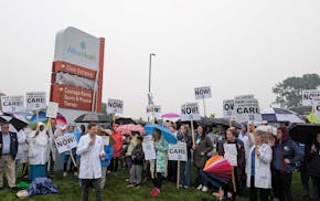 Dr. Matt Hoffman, with microphone, explains the contract issues that compelled about 50 doctors, nurse practitioners and others to picket outside Alli