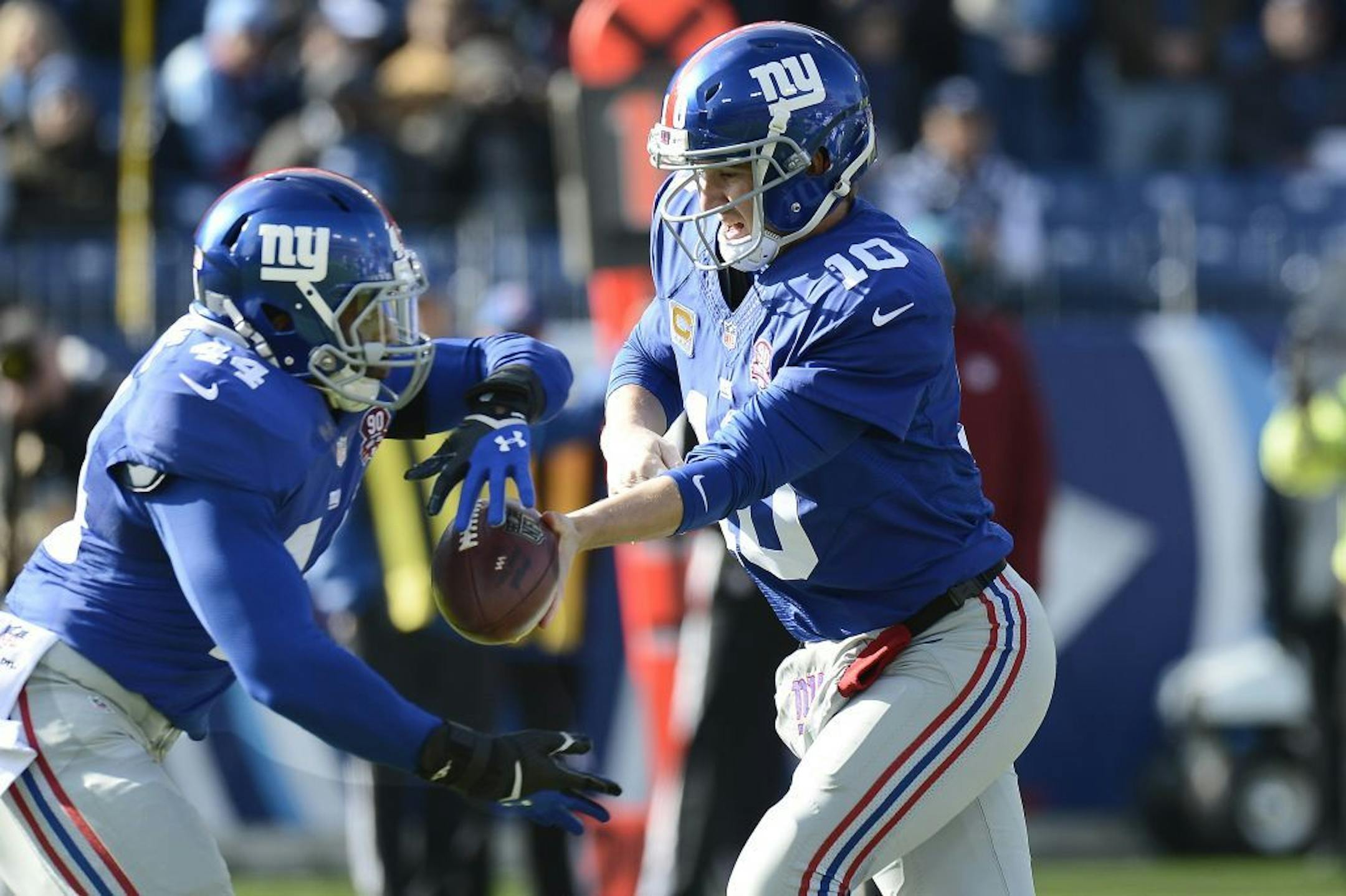 New York Giants quarterback Eli Manning (10) hands off to running back Andre Williams (44) in the first half of an NFL football game against the Tennessee Titans Sunday, Dec. 7, 2014, in Nashville, Tenn.
