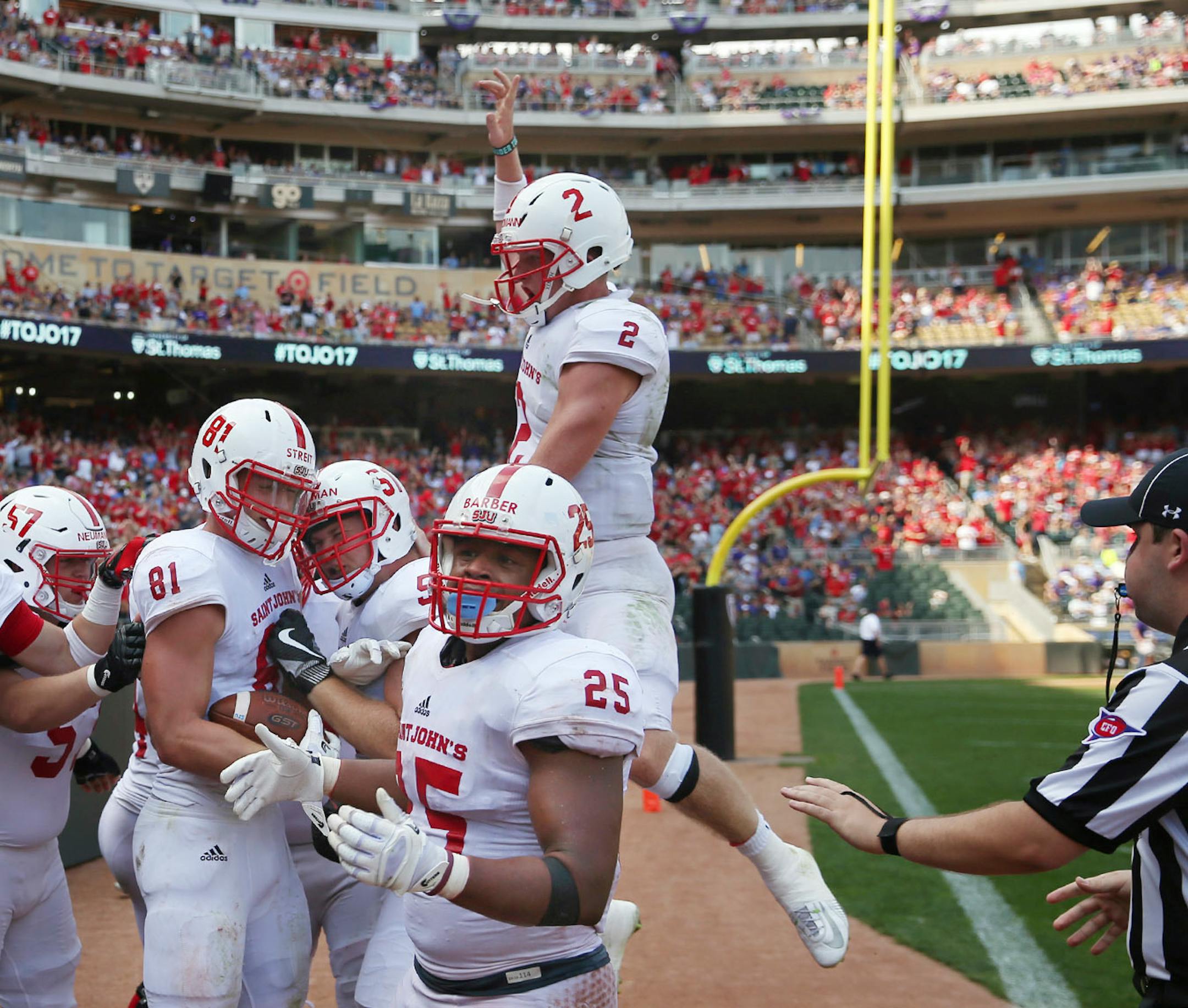 St. John's University tight end Jared Streit (81) was congratulated by his teammates after he ran the ball in for a touchdown off a long pass in the first half.