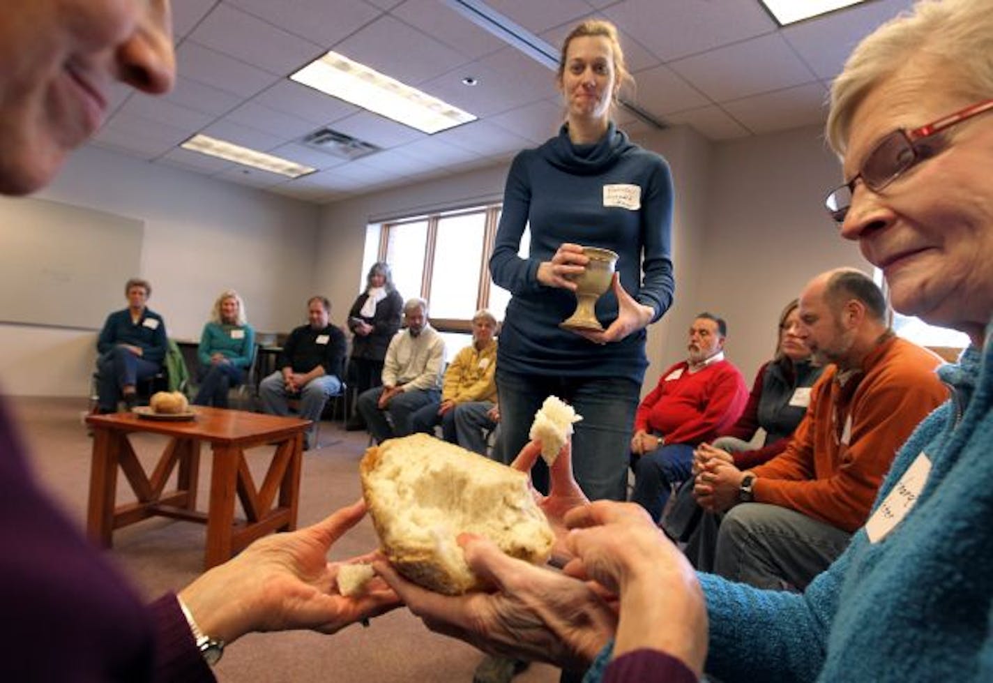 Sheila Bennett, left, broke bread with Barbara Reichter as it was passed around the retreat circle. The Rev. Brooke Heerwald Steiner followed with the wine.