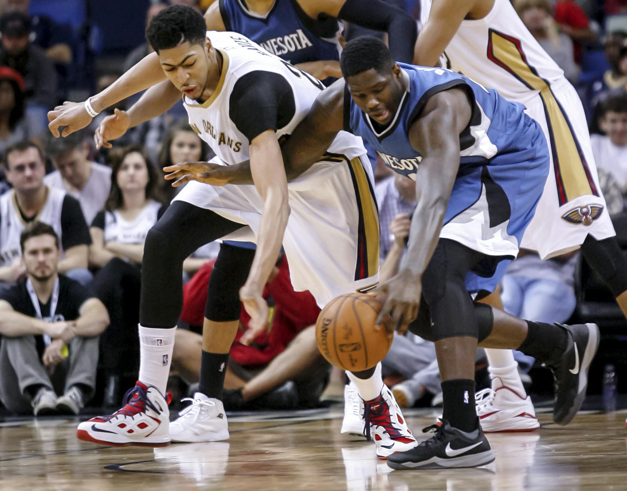 New Orleans Pelicans forward Anthony Davis (23) and Minnesota Timberwolves forward Anthony Bennett (24) battle for a loose ball during the second half of an NBA basketball game in New Orleans, Sunday, March 29, 2015. The Pelicans won 110-88. (AP Photo/Scott Threlkeld)