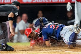 Los Angeles Angels' Magneuris Sierra, center, is tagged out at the plate by Minnesota Twins catcher Gary Sanchez, right, failing to stretch a two-run 