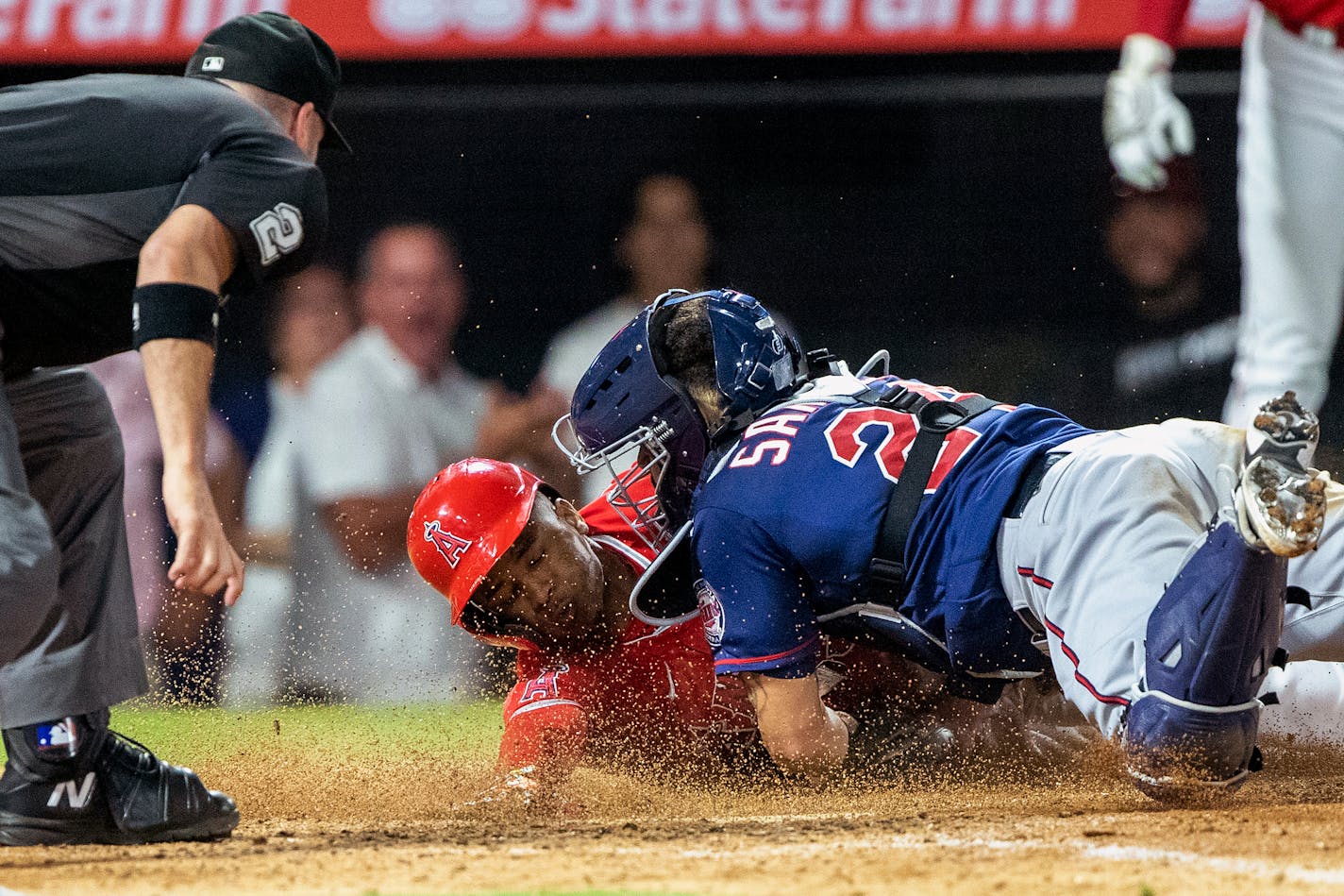 Los Angeles Angels' Magneuris Sierra, center, is tagged out at the plate by Minnesota Twins catcher Gary Sanchez, right, failing to stretch a two-run triple into an inside-the-park home run during the ninth inning of a baseball game in Anaheim, Calif., Saturday, Aug. 13, 2022. (AP Photo/Alex Gallardo)