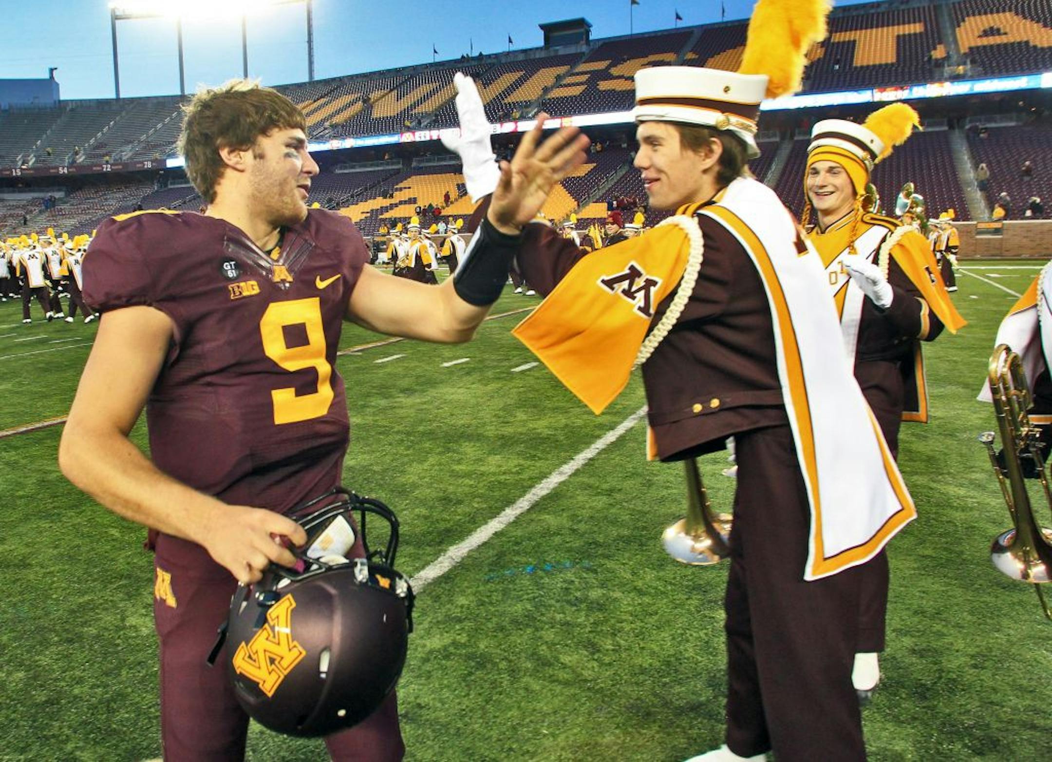 Minnesota quaterback Philip Nelson was congratulated by band members at the end of the game.