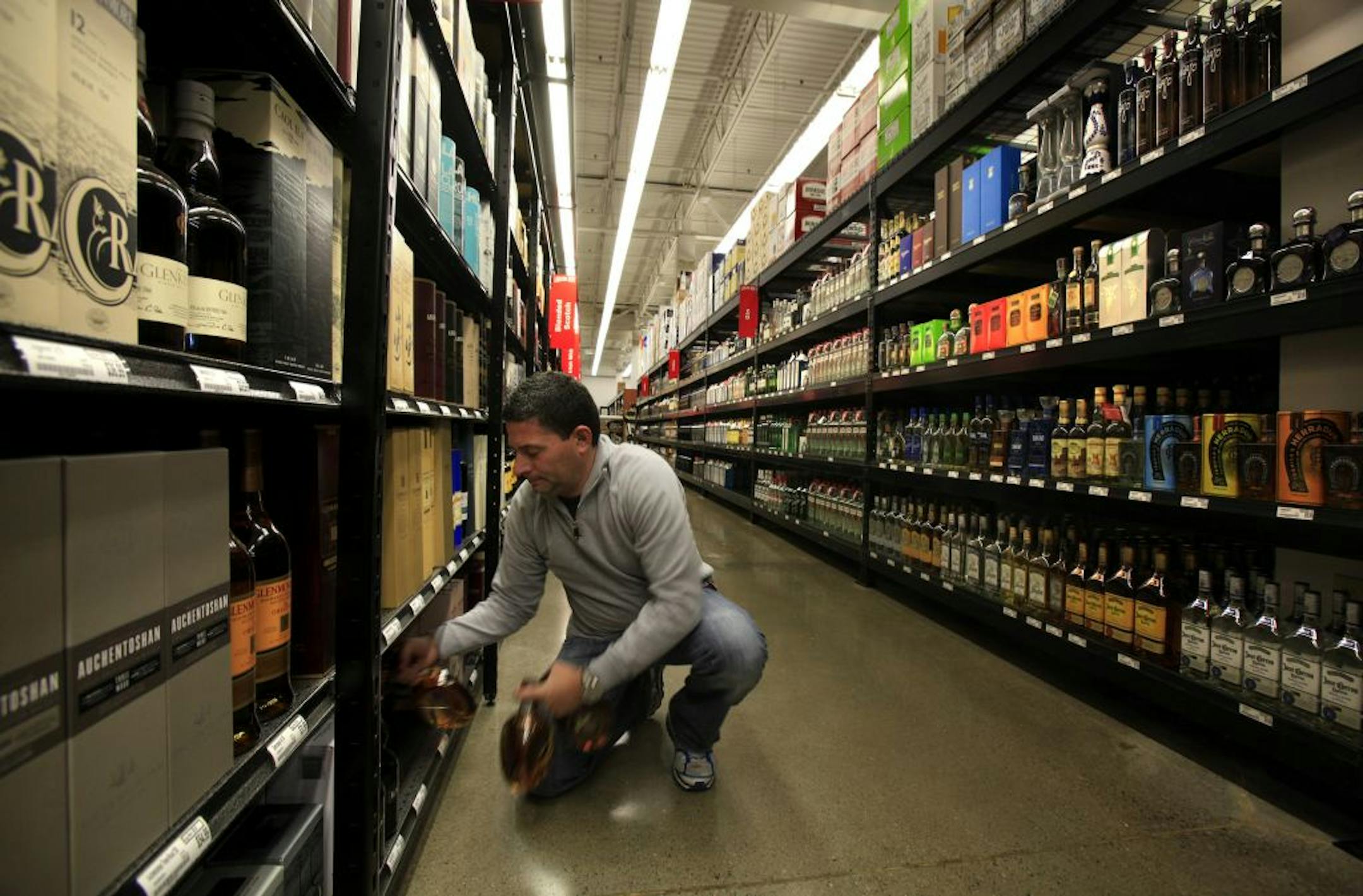 Owner John Wolf stocked shelves at Liquor Boy, a 10,000-square-foot store in St. Louis Park that has instituted an everyday-low-price structure. the first warehouse-style liquor store to open in the Twin Cities since Costco and Sam's Club came to town.