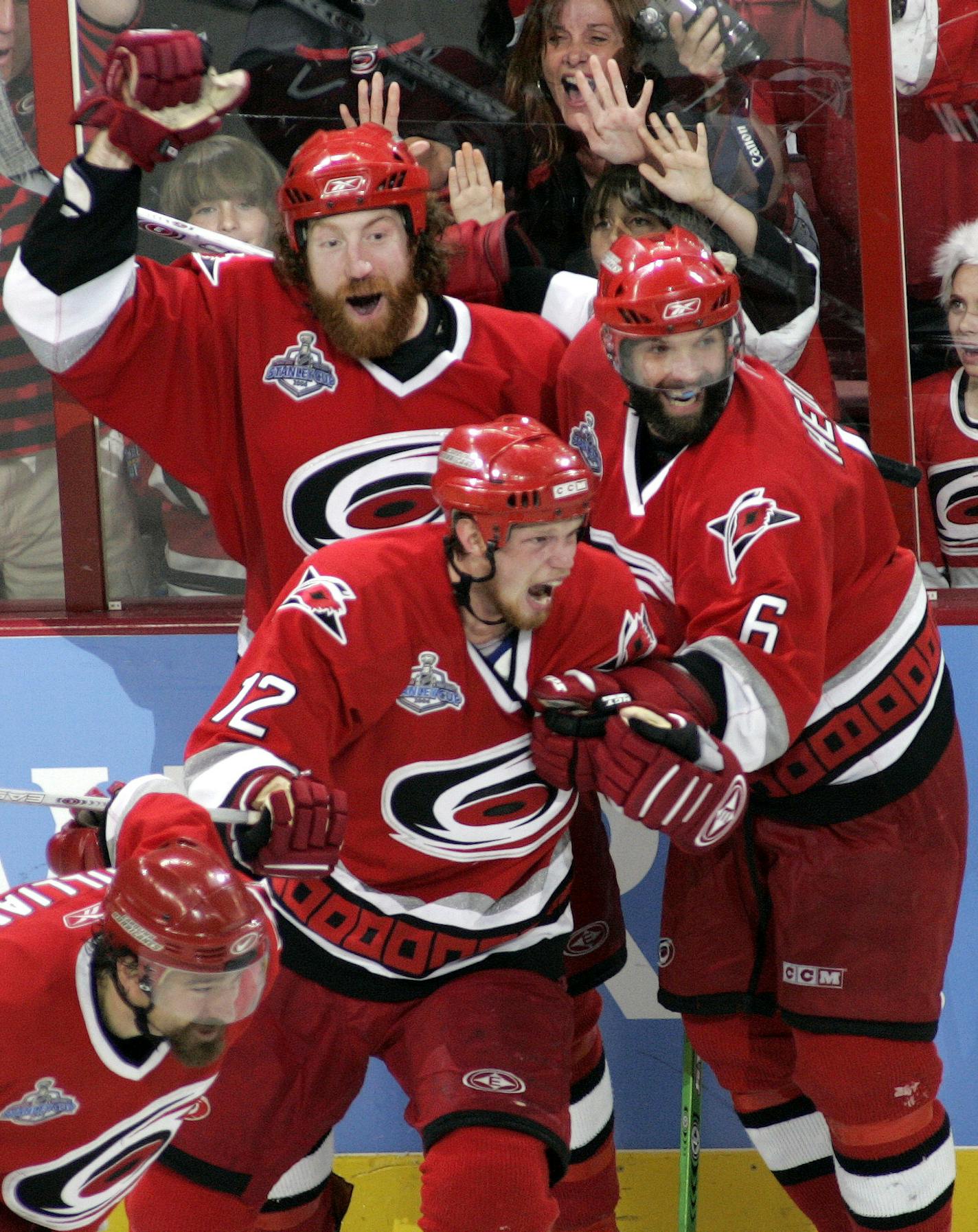 Carolina Hurricanes' Eric Staal (12), Bret Hedican (6) and Mike Commodore, rear left, celebrate an open net goal by teammate Justin Williams, front left, in the third period of Game 7 of the Stanley Cup hockey finals Monday, June 19, 2006 in Raleigh, N.C. The Hurricanes defeated the Oilers 3-1 to win the Stanley Cup. (AP Photo/Karl DeBlaker) ORG XMIT: NCPK118