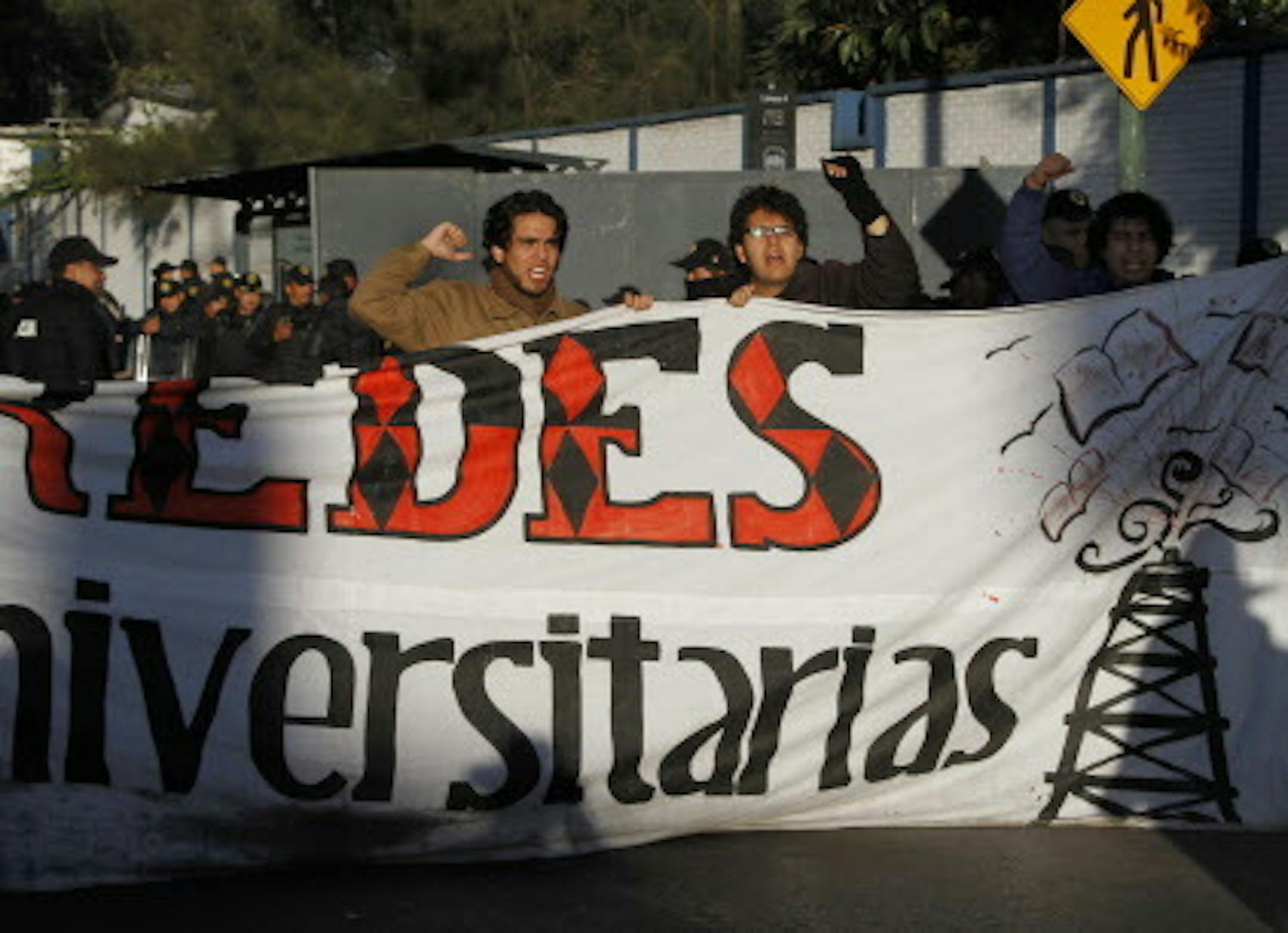 Demonstrators shout slogans against political reforms in front of riot police guarding outside at the National Congress in protest against the newly approved energy reform bill in Mexico City, Thursday, Dec. 12, 2013. Mexico's Senate, in the early hours of Wednesday approved the most dramatic oil reform in decades, moving the country closer to opening its state-run sector to private companies and investment. With the Senate passage, the bill also must be approved by the lower house and by the le